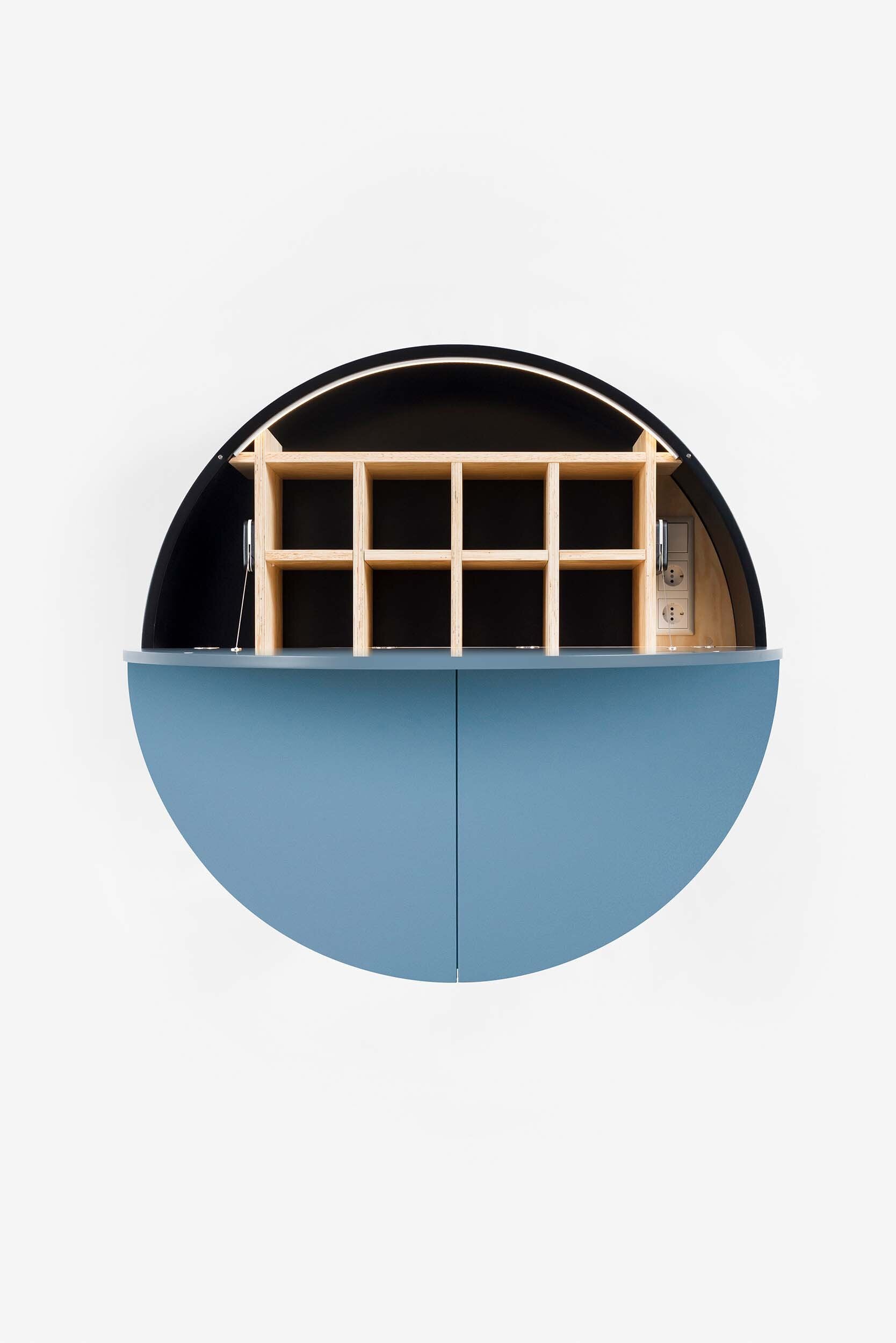 A sleek, round wall-mounted cabinet that transforms into a workspace, dressing table, or bar, featuring adjustable height and customizable shelving.