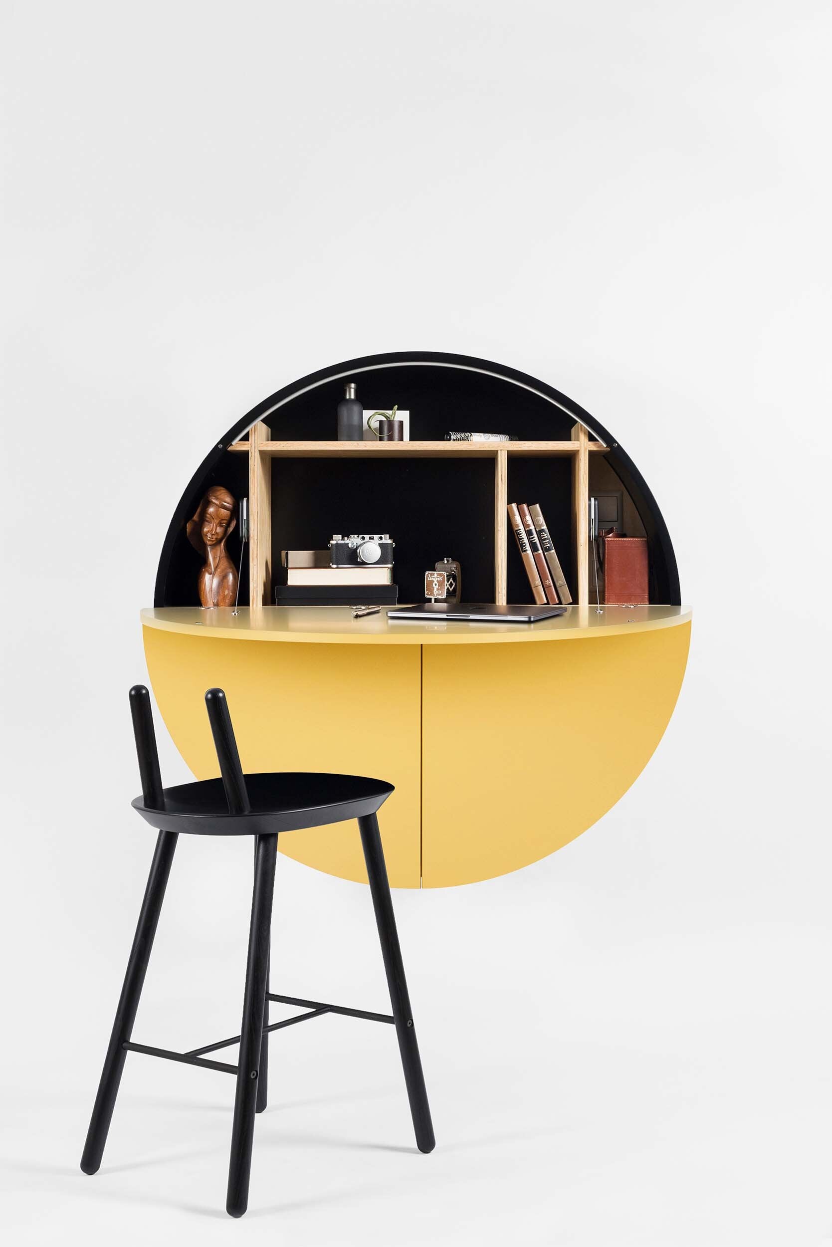 A sleek, round wall-mounted cabinet that transforms into a workspace, dressing table, or bar, featuring adjustable height and customizable shelving.