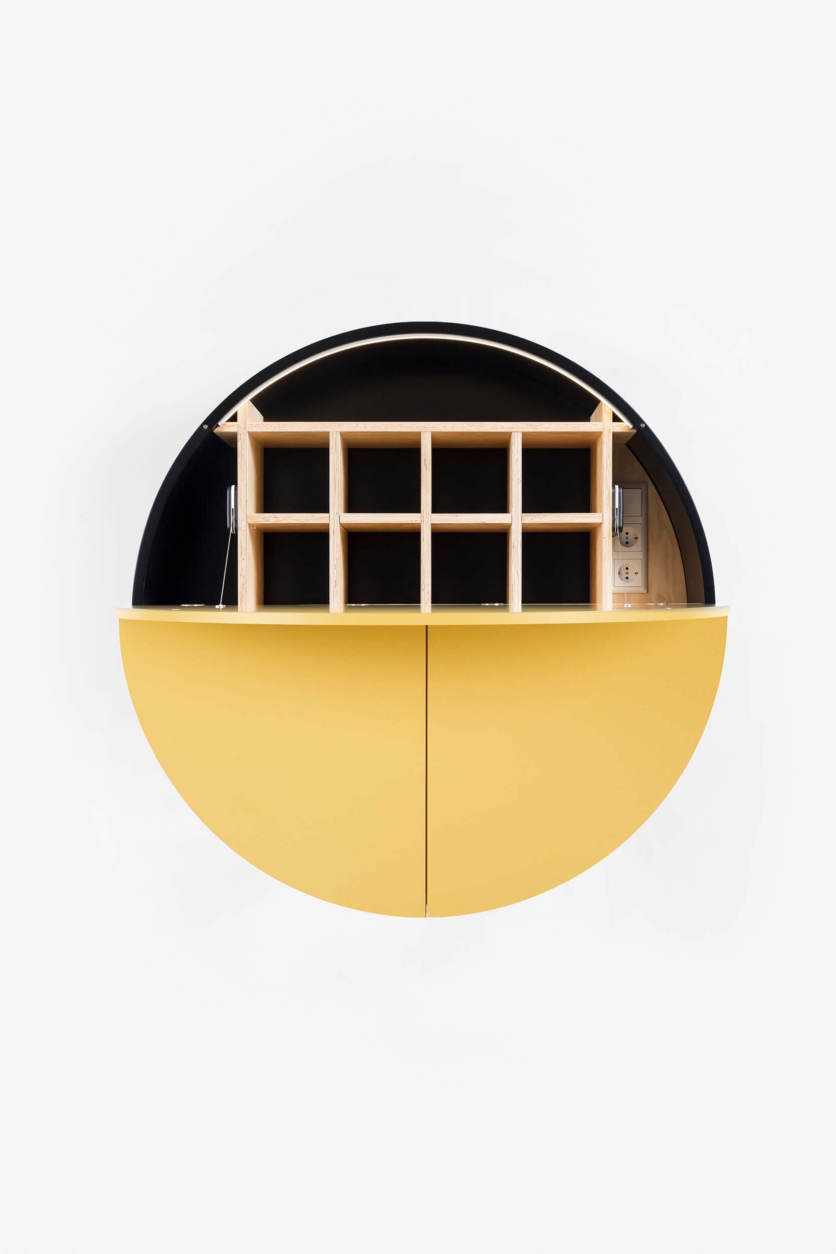 A sleek, round wall-mounted cabinet that transforms into a workspace, dressing table, or bar, featuring adjustable height and customizable shelving.