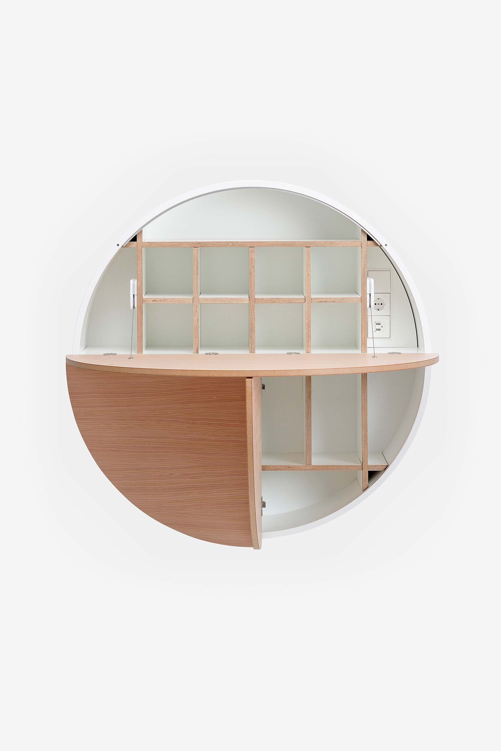 A sleek, round wall-mounted cabinet that transforms into a workspace, dressing table, or bar, featuring adjustable height and customizable shelving.