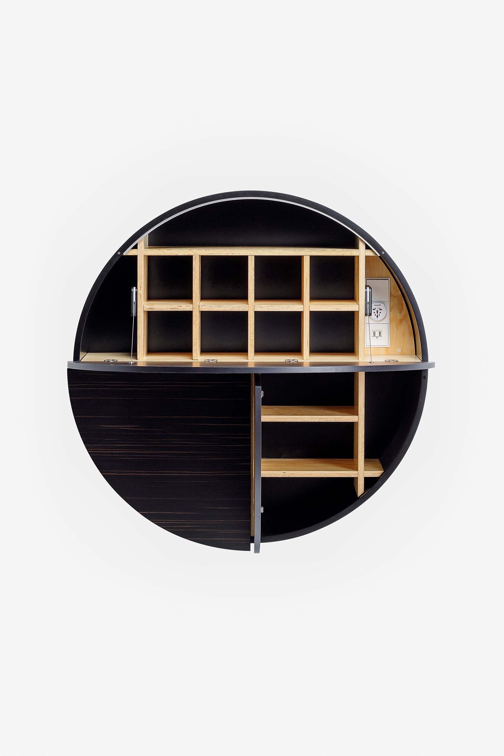 A sleek, round wall-mounted cabinet that transforms into a workspace, dressing table, or bar, featuring adjustable height and customizable shelving.