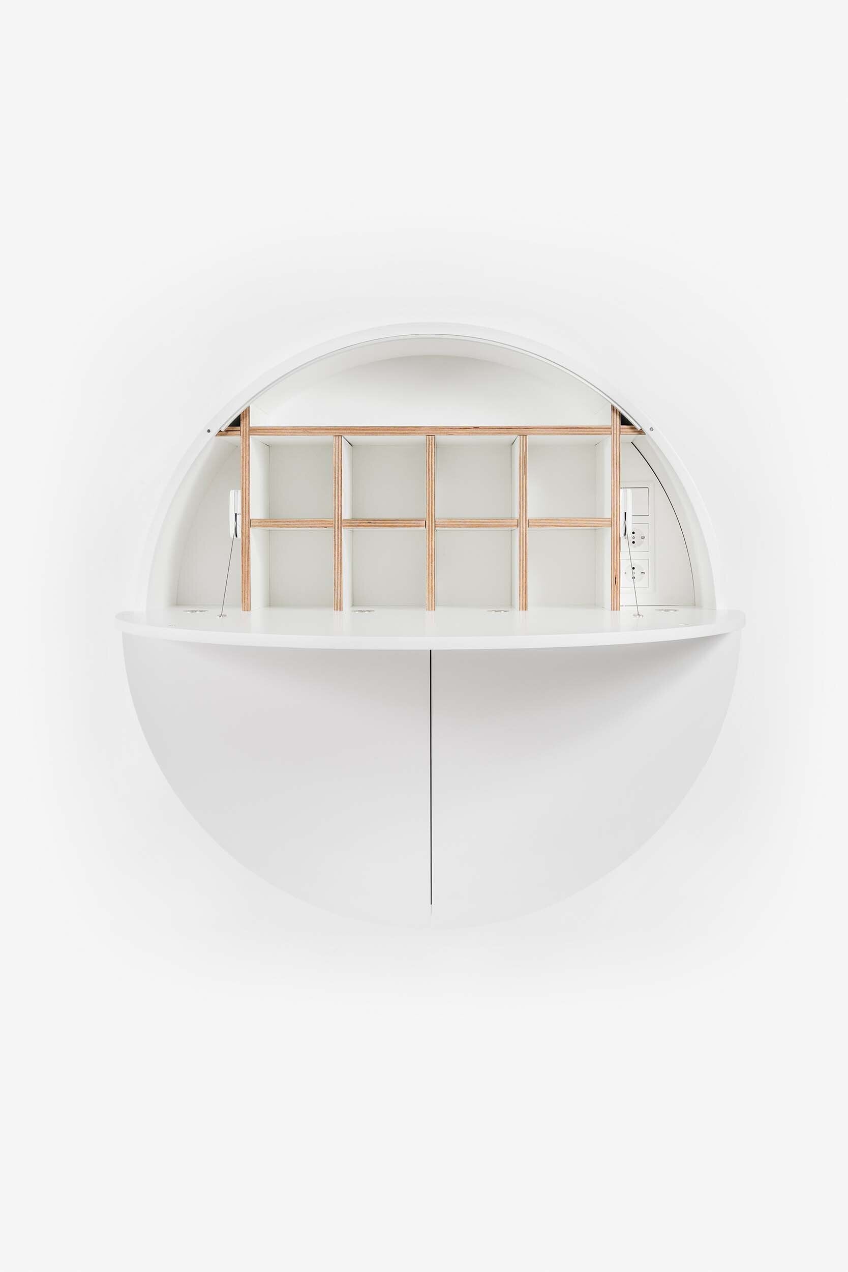 A sleek, round wall-mounted cabinet that transforms into a workspace, dressing table, or bar, featuring adjustable height and customizable shelving.