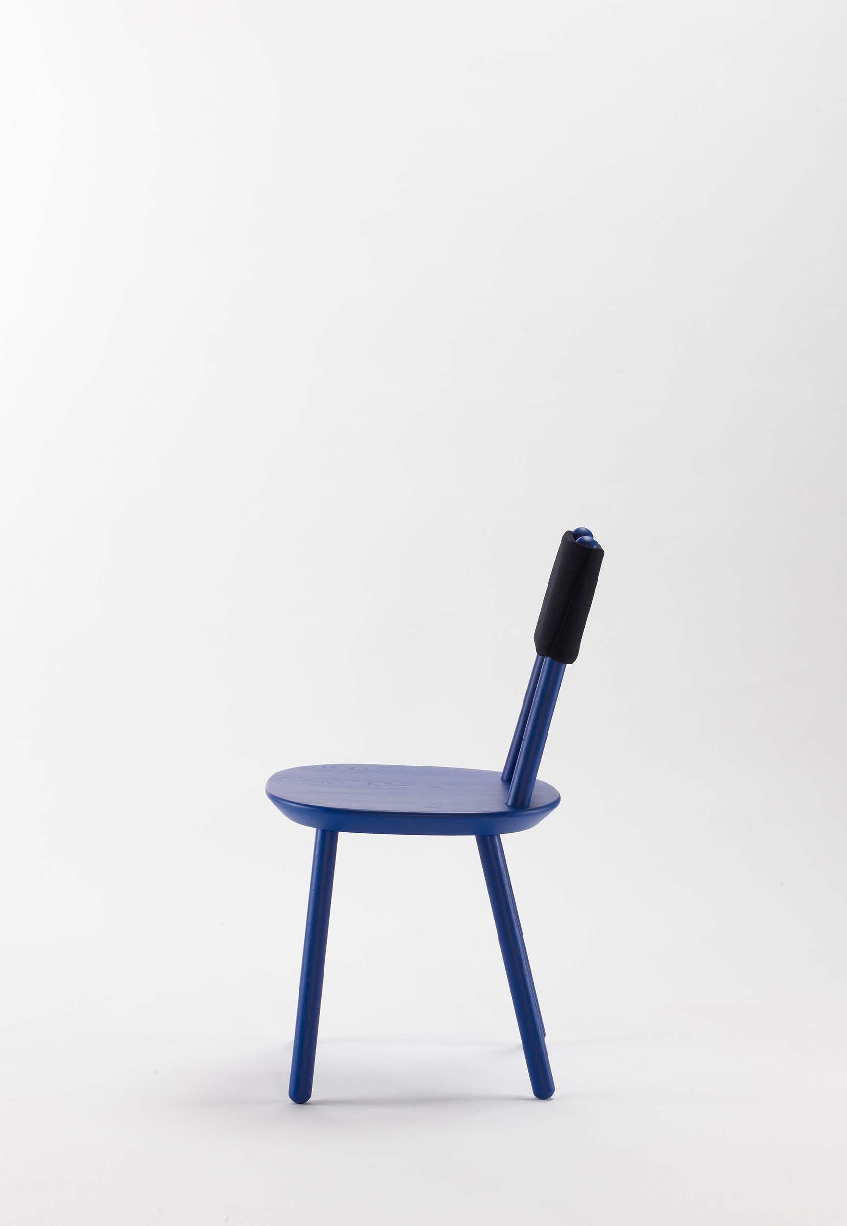 Naïve Dining Chair featuring a minimalist design with a solid ash seat and six equal-length legs, showcasing its playful and ergonomic structure.