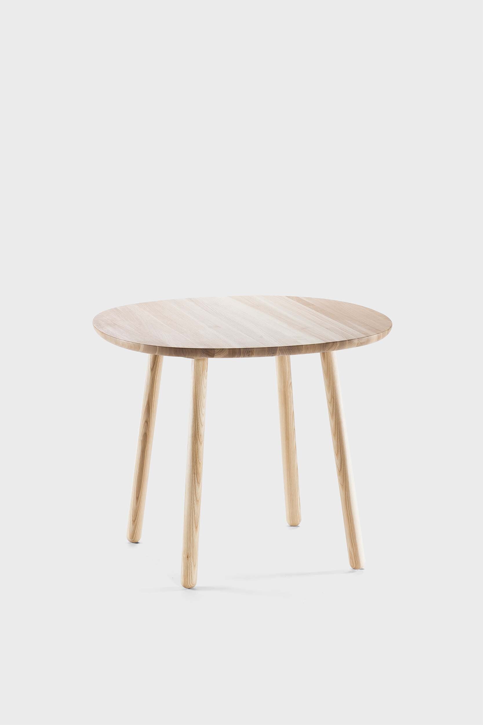 Naïve Dining Table featuring a roundish ash wood tabletop with sturdy legs, showcasing a minimalist design in a cozy dining setting.