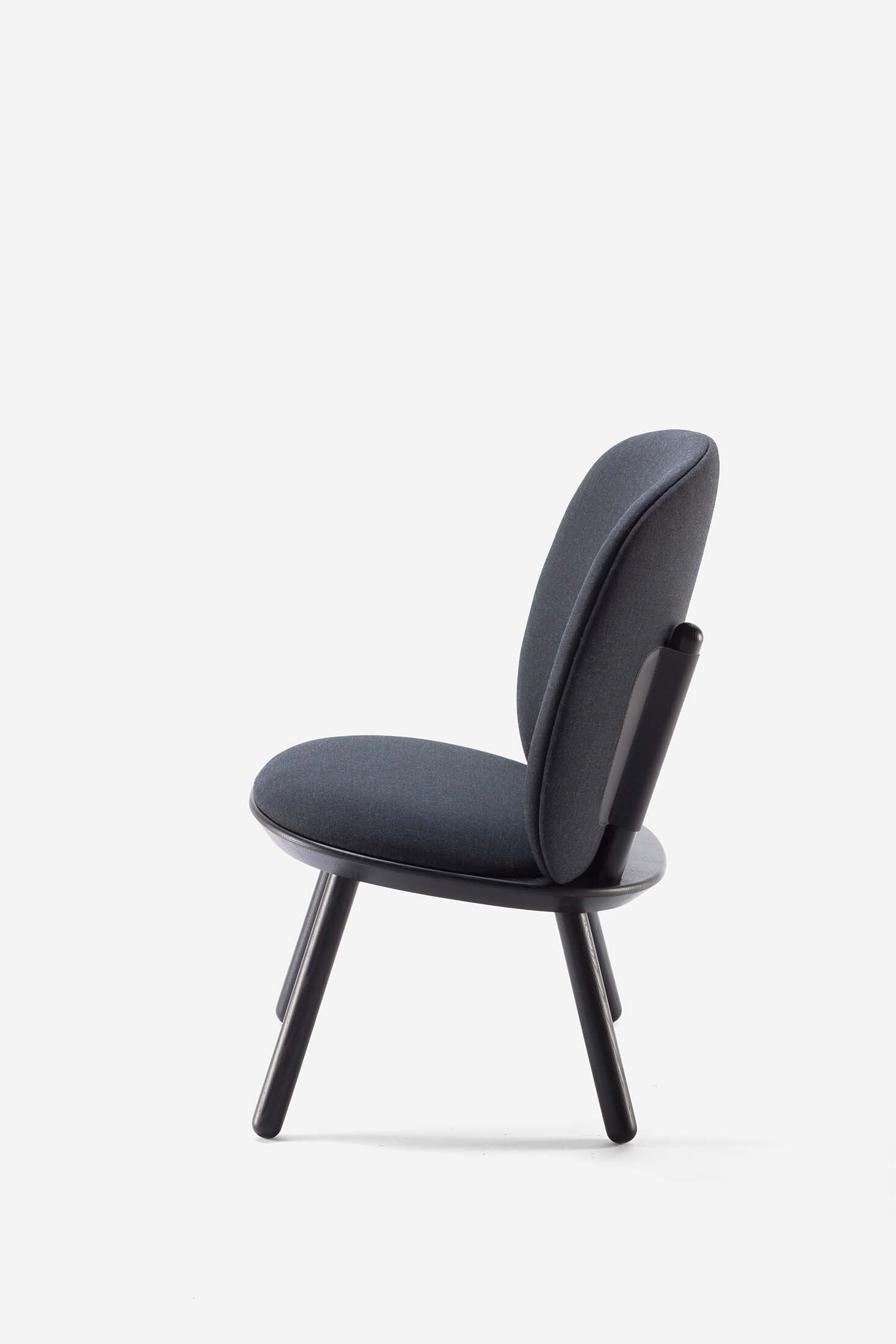 Naïve Low Chair featuring a large leather strap, wooden body, and textile upholstery, designed for comfort and style.