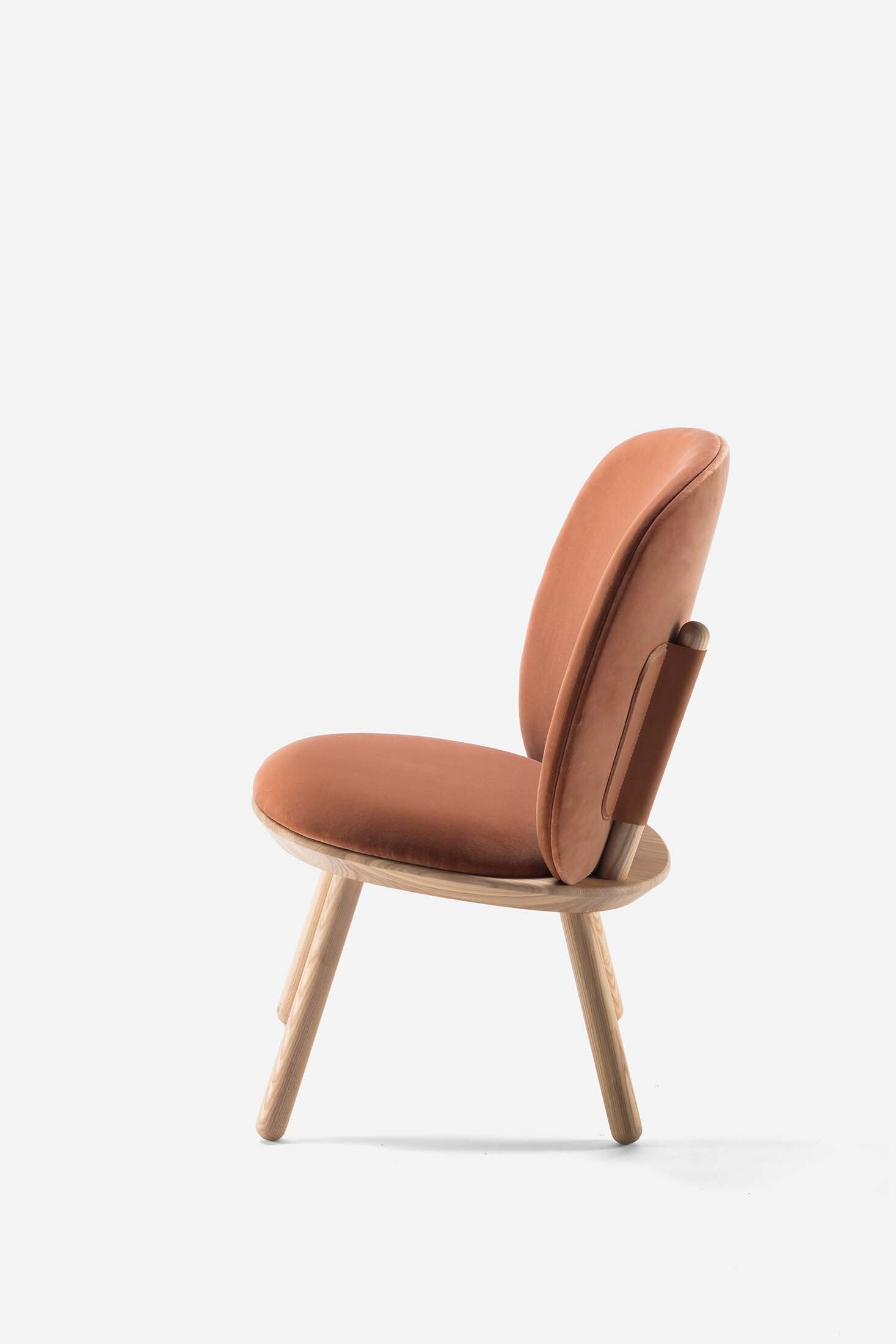 Naïve Low Chair featuring a large leather strap, wooden body, and textile upholstery, designed for comfort and style.