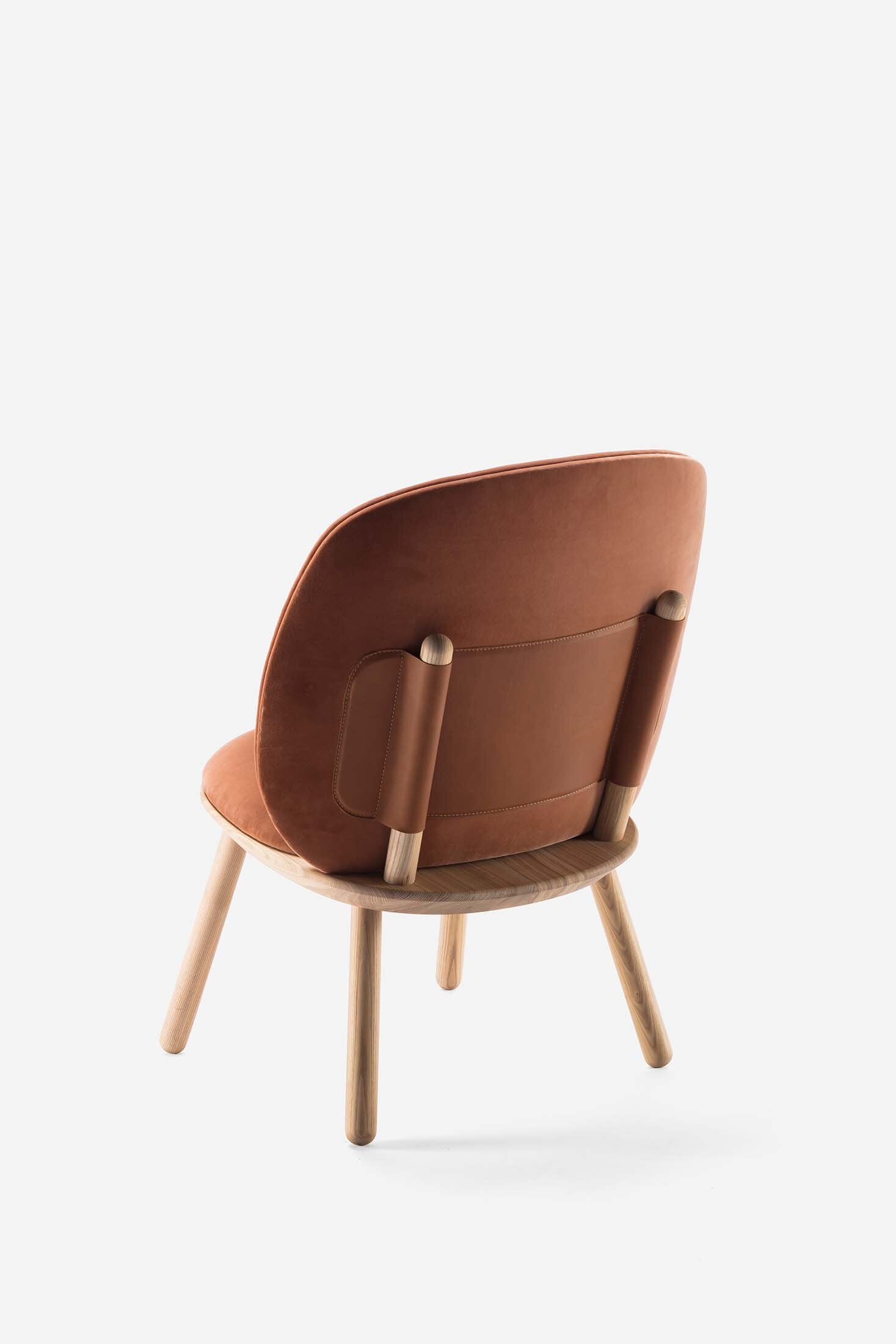 Naïve Low Chair featuring a large leather strap, wooden body, and textile upholstery, designed for comfort and style.