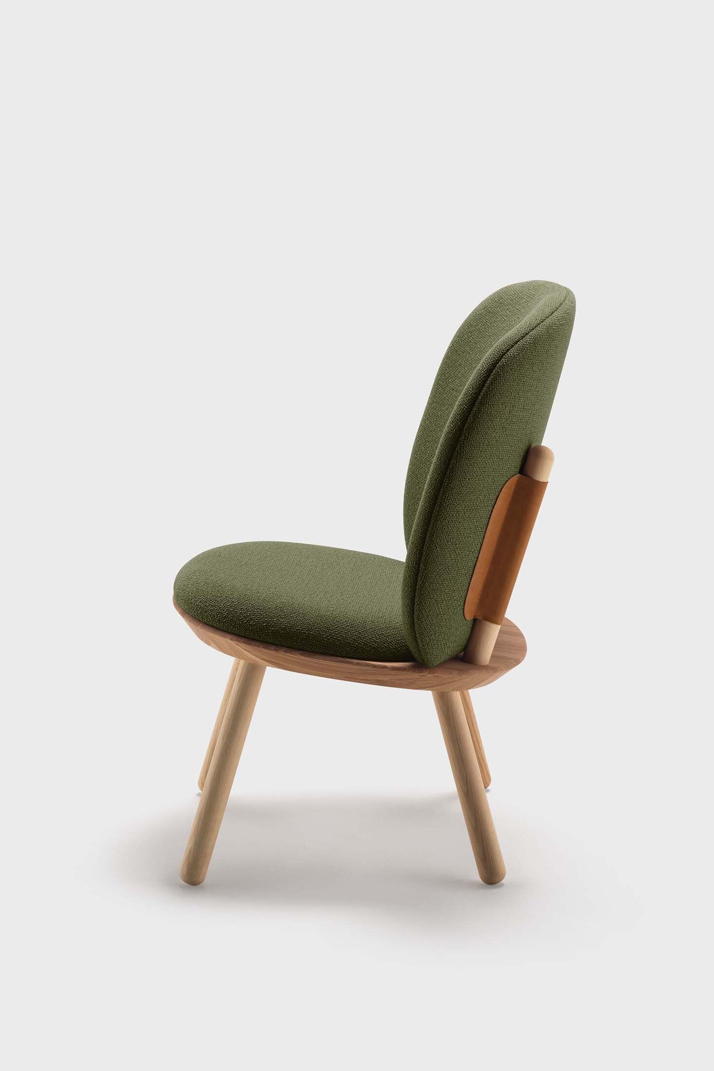 Naïve Low Chair featuring a large leather strap, wooden body, and textile upholstery, designed for comfort and style.