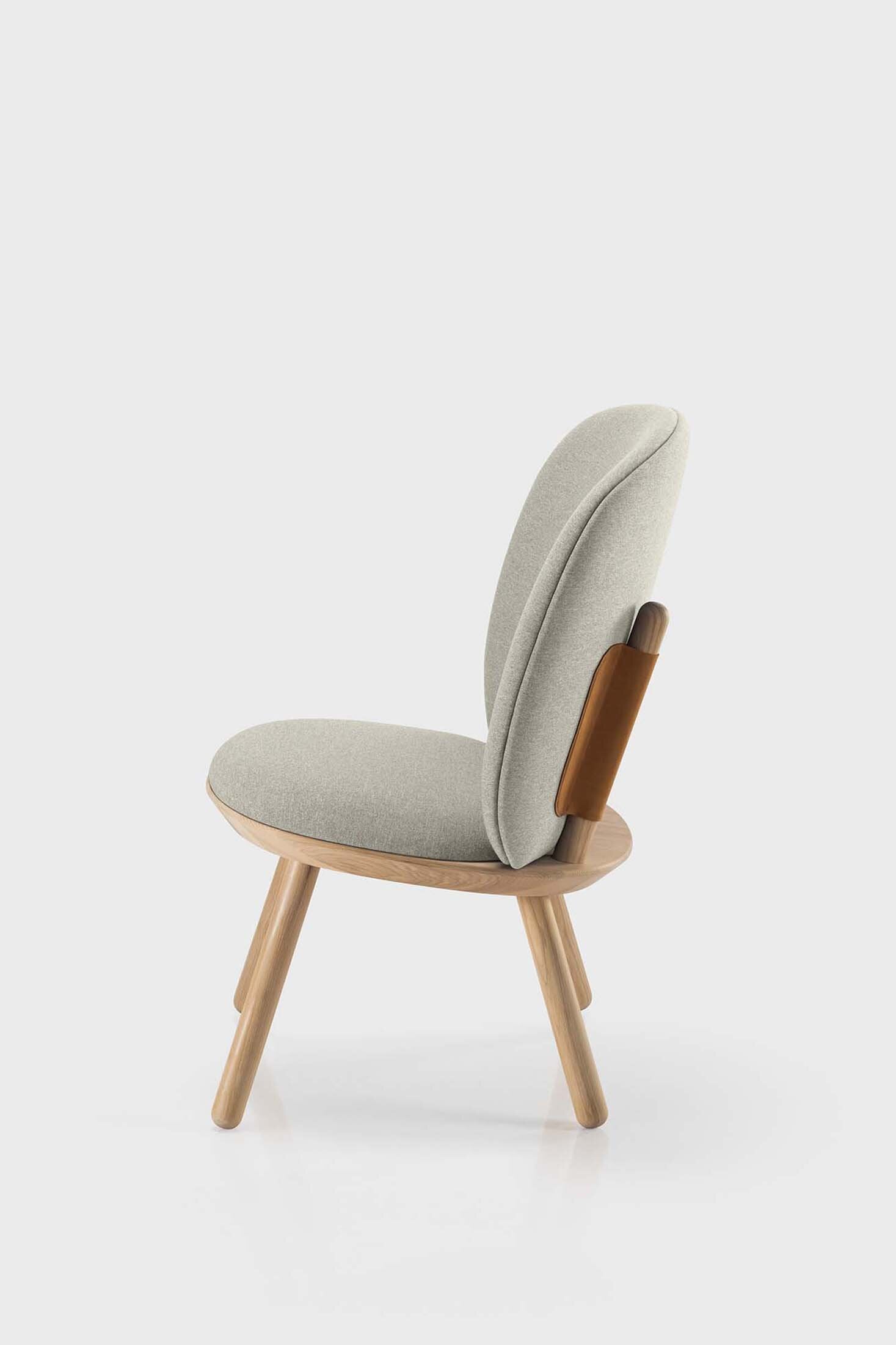 Naïve Low Chair featuring a large leather strap, wooden body, and textile upholstery, designed for comfort and style.