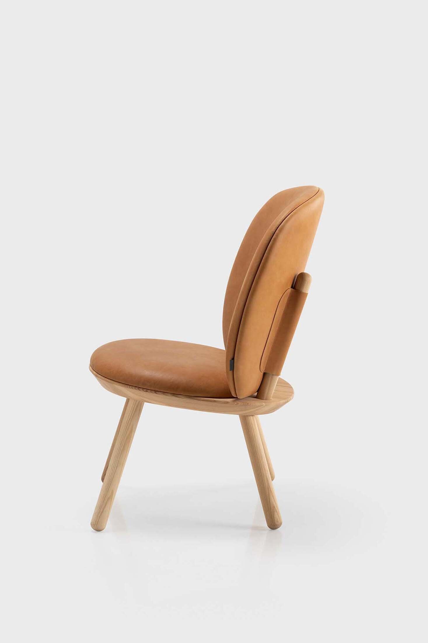 Naïve Low Chair featuring a large leather strap, wooden body, and textile upholstery, designed for comfort and style.