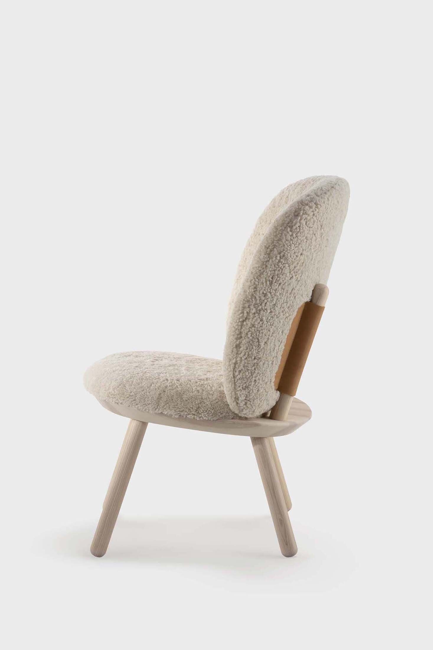 Naïve Low Chair featuring a large leather strap, wooden body, and textile upholstery, designed for comfort and style.