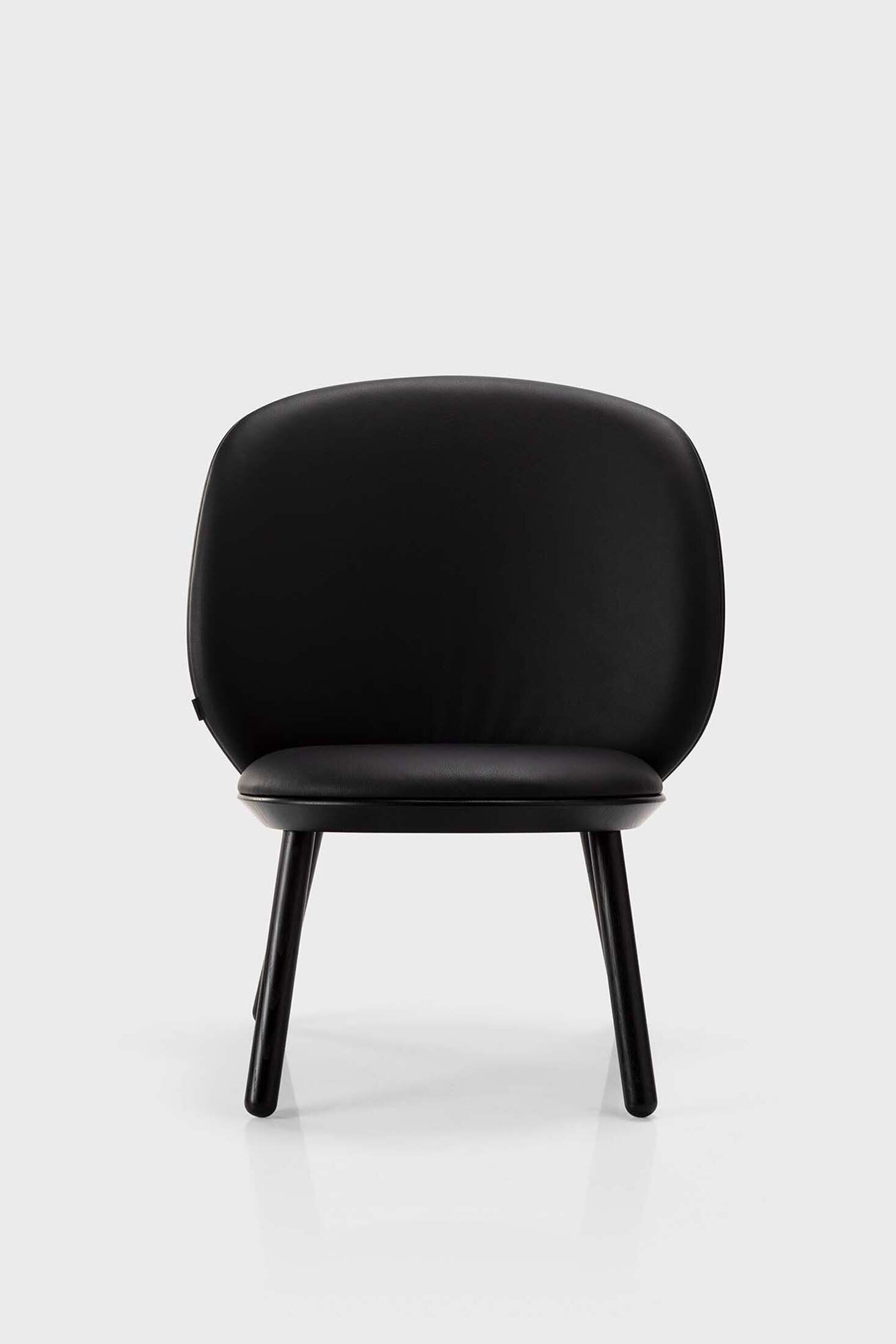 Naïve Low Chair featuring a large leather strap, wooden body, and textile upholstery, designed for comfort and style.