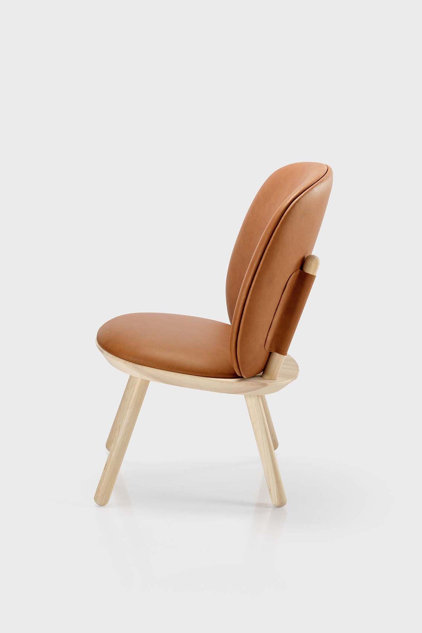 Naïve Low Chair featuring a large leather strap, wooden body, and textile upholstery, designed for comfort and style.