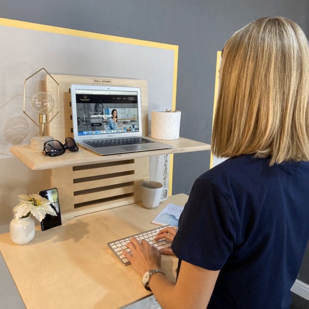 WallStand adjustable wall-mounted standing desk with two shelves, showcasing a sleek design and premium Baltic Birch plywood material.