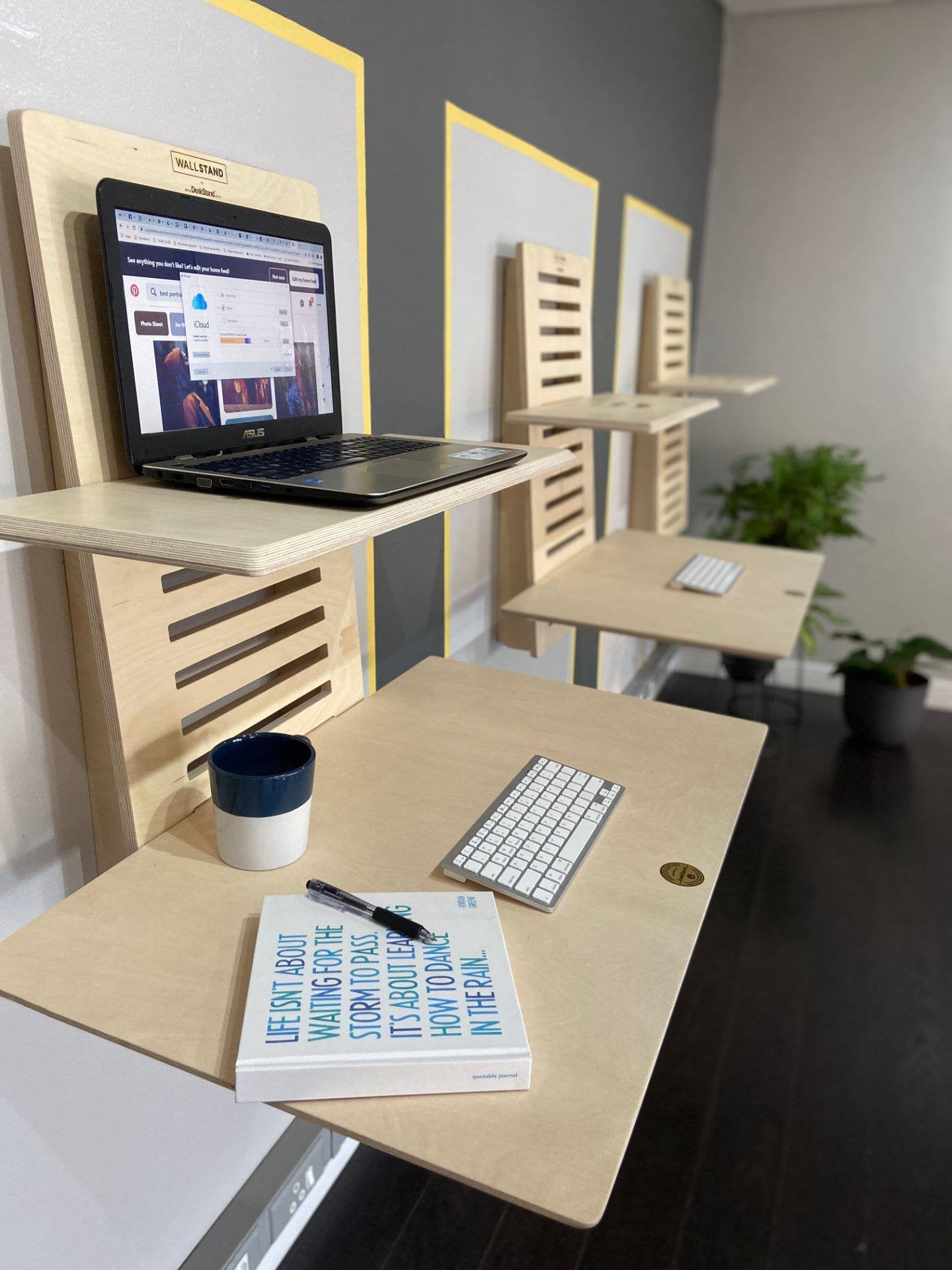 WallStand adjustable wall-mounted standing desk with two shelves, showcasing a sleek design and premium Baltic Birch plywood material.