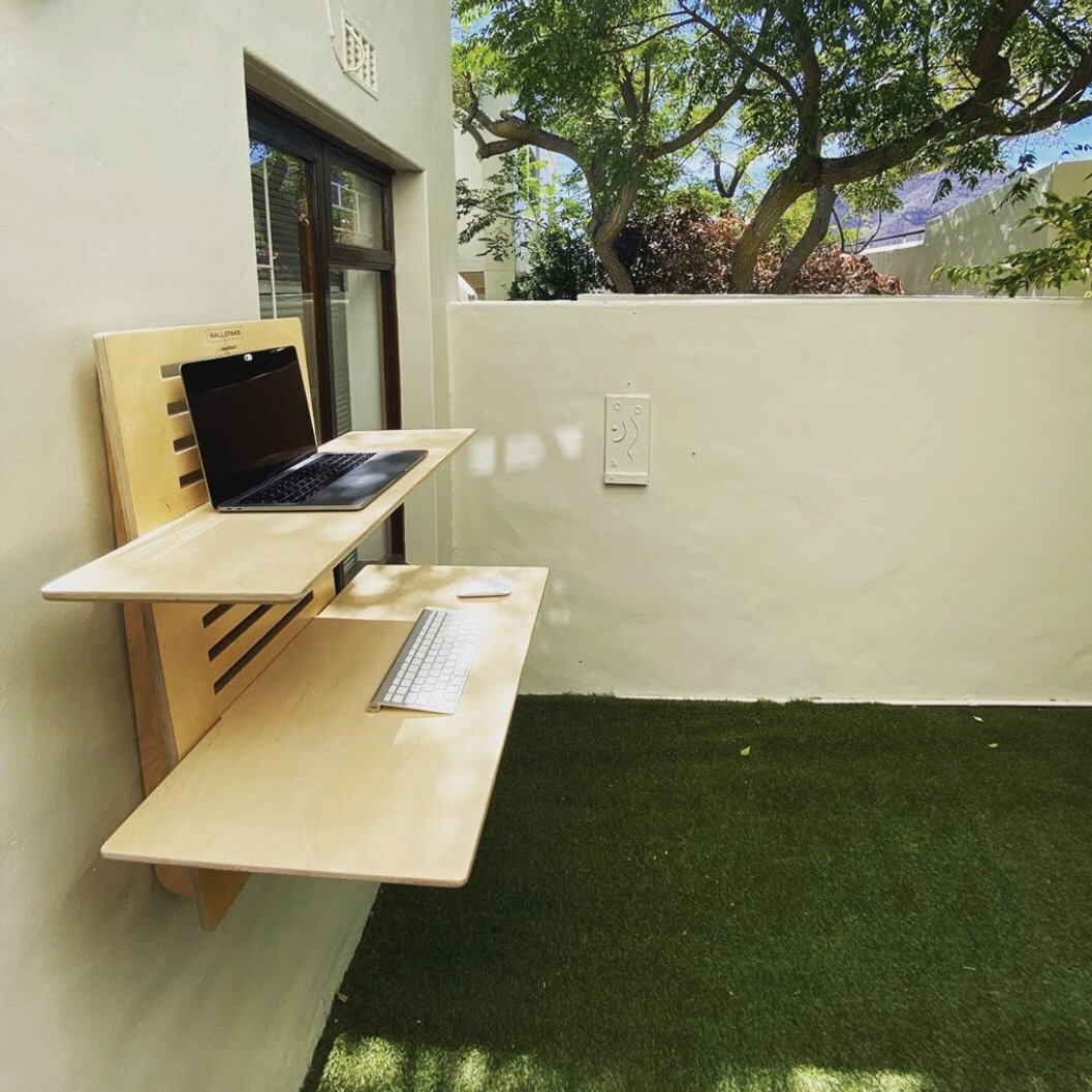 WallStand adjustable wall-mounted standing desk with two shelves, showcasing a sleek design and premium Baltic Birch plywood material.