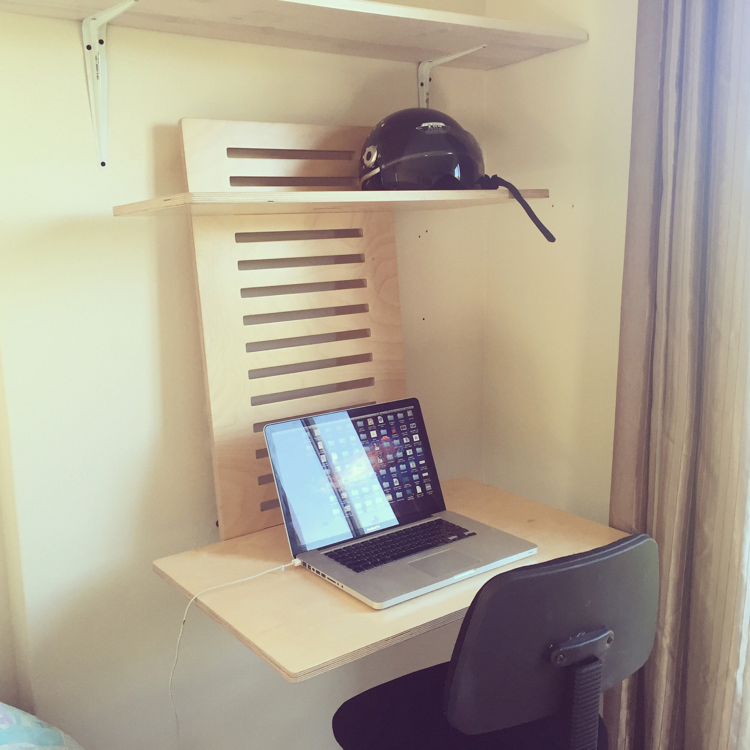 WallStand adjustable wall-mounted standing desk with two shelves, showcasing a sleek design and premium Baltic Birch plywood material.