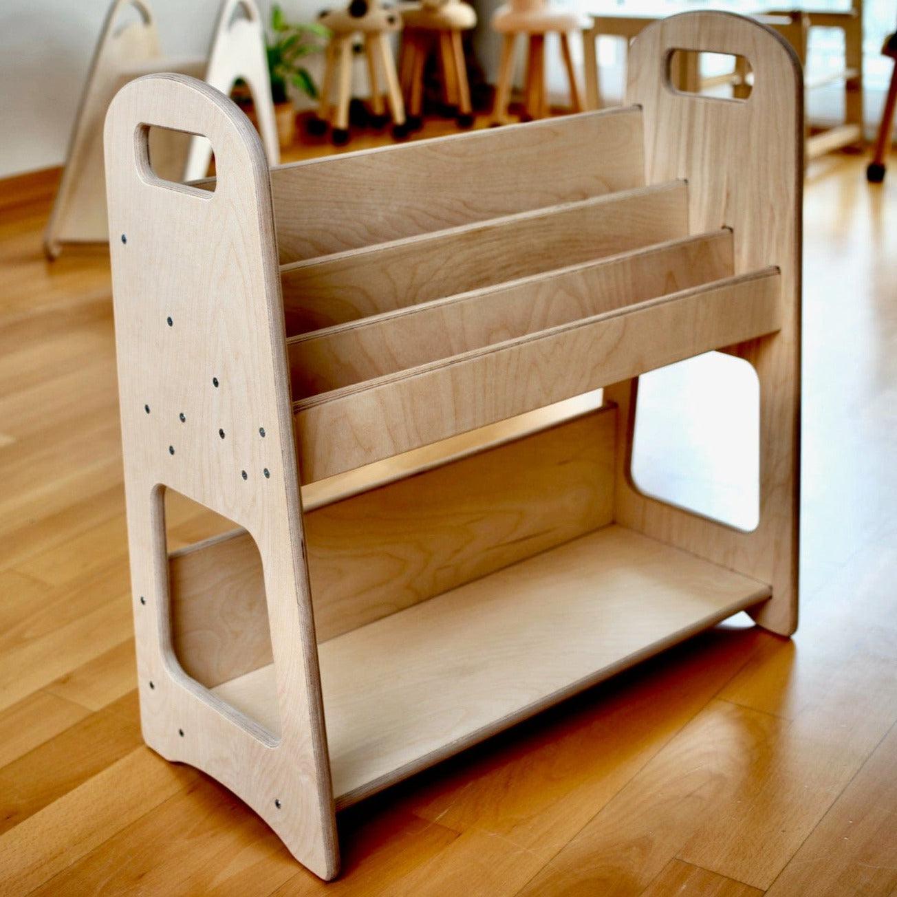 A large wooden bookshelf designed for children's rooms, featuring adjustable shelves and a natural wood finish, ideal for Montessori-style storage.