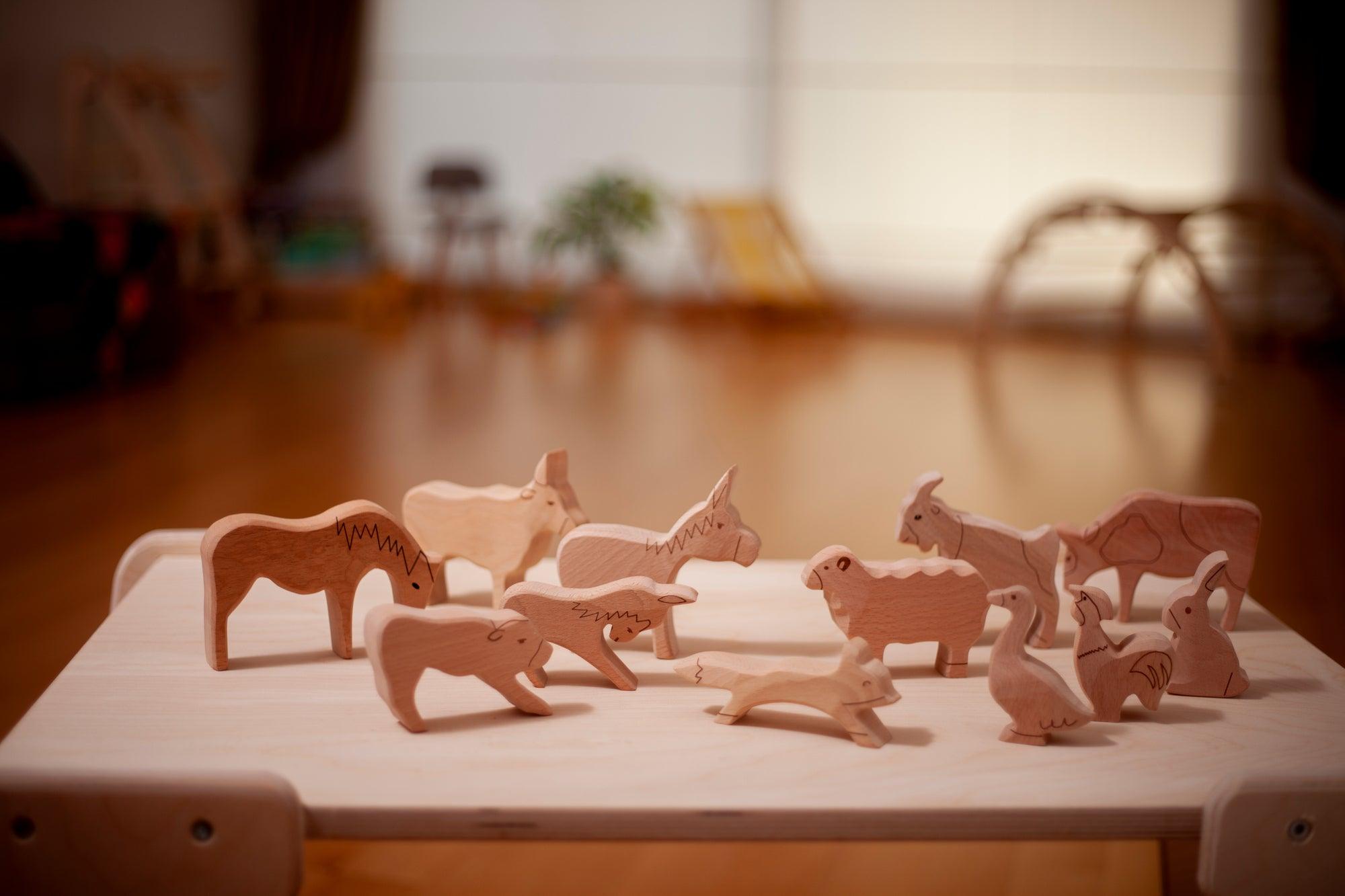 A colorful Wooden Farm Animals Set featuring intricately designed figures of cows, horses, pigs, ducks, and chickens, perfect for children's imaginative play.