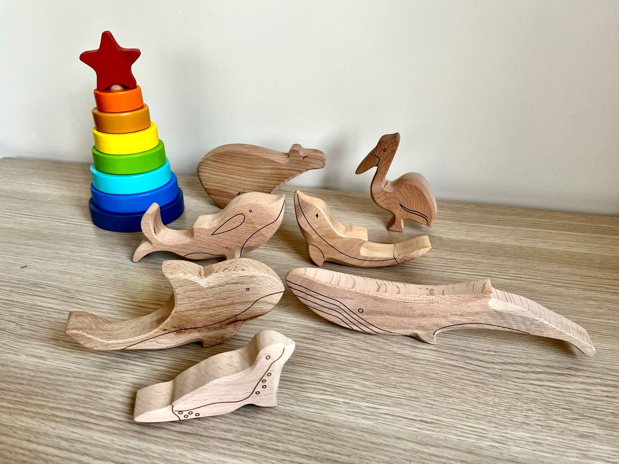 A colorful Wooden Ocean Animals Set featuring a dolphin, whale, sea turtle, starfish, and clownfish, designed for children's play and education.