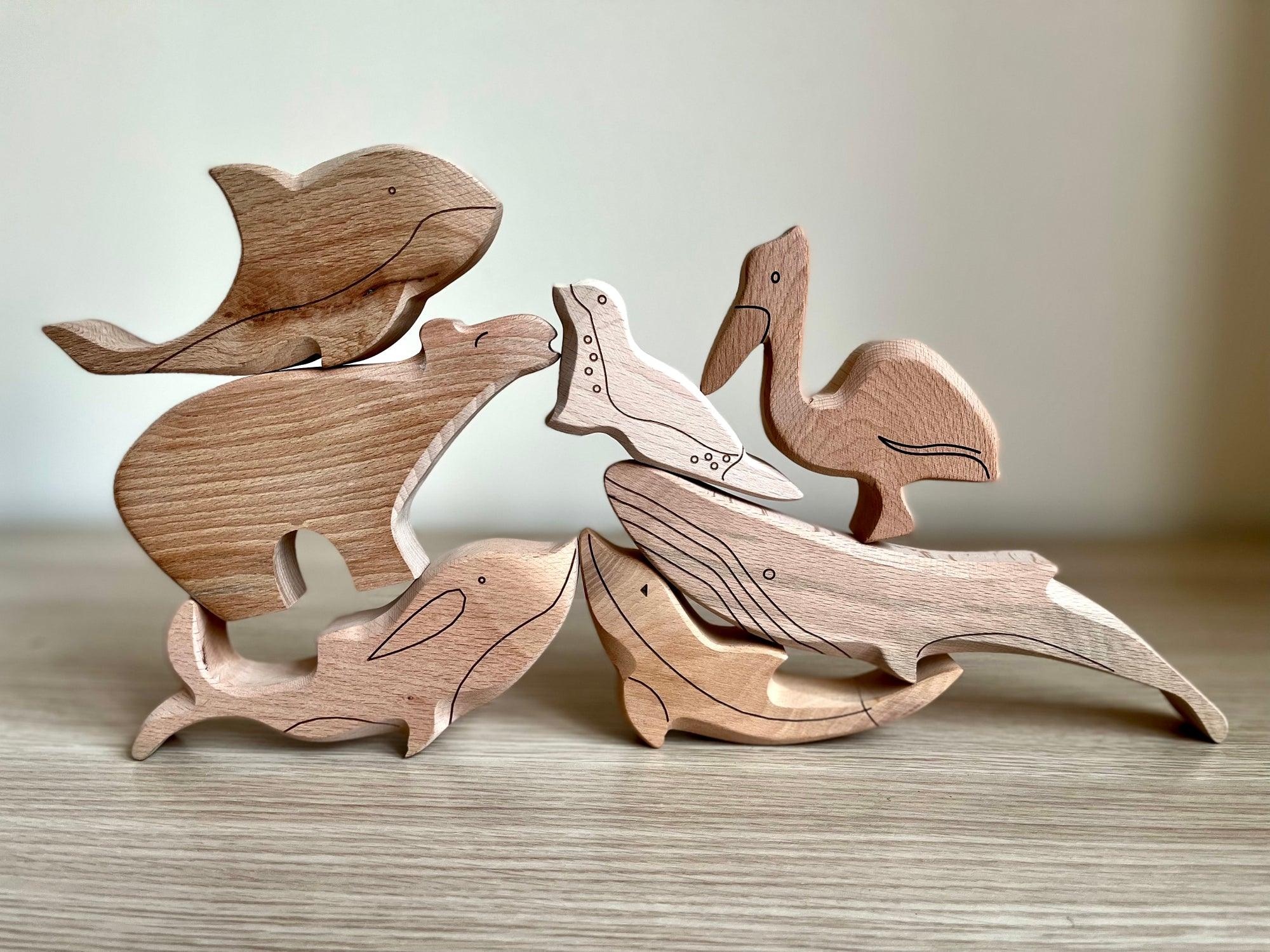 A colorful Wooden Ocean Animals Set featuring a dolphin, whale, sea turtle, starfish, and clownfish, designed for children's play and education.