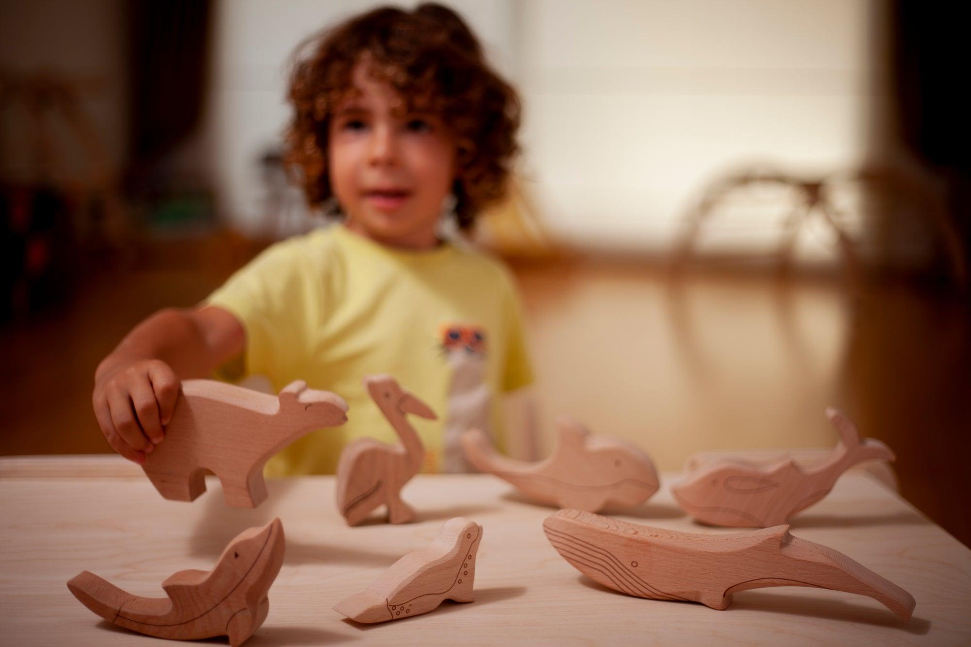 A colorful Wooden Ocean Animals Set featuring a dolphin, whale, sea turtle, starfish, and clownfish, designed for children's play and education.