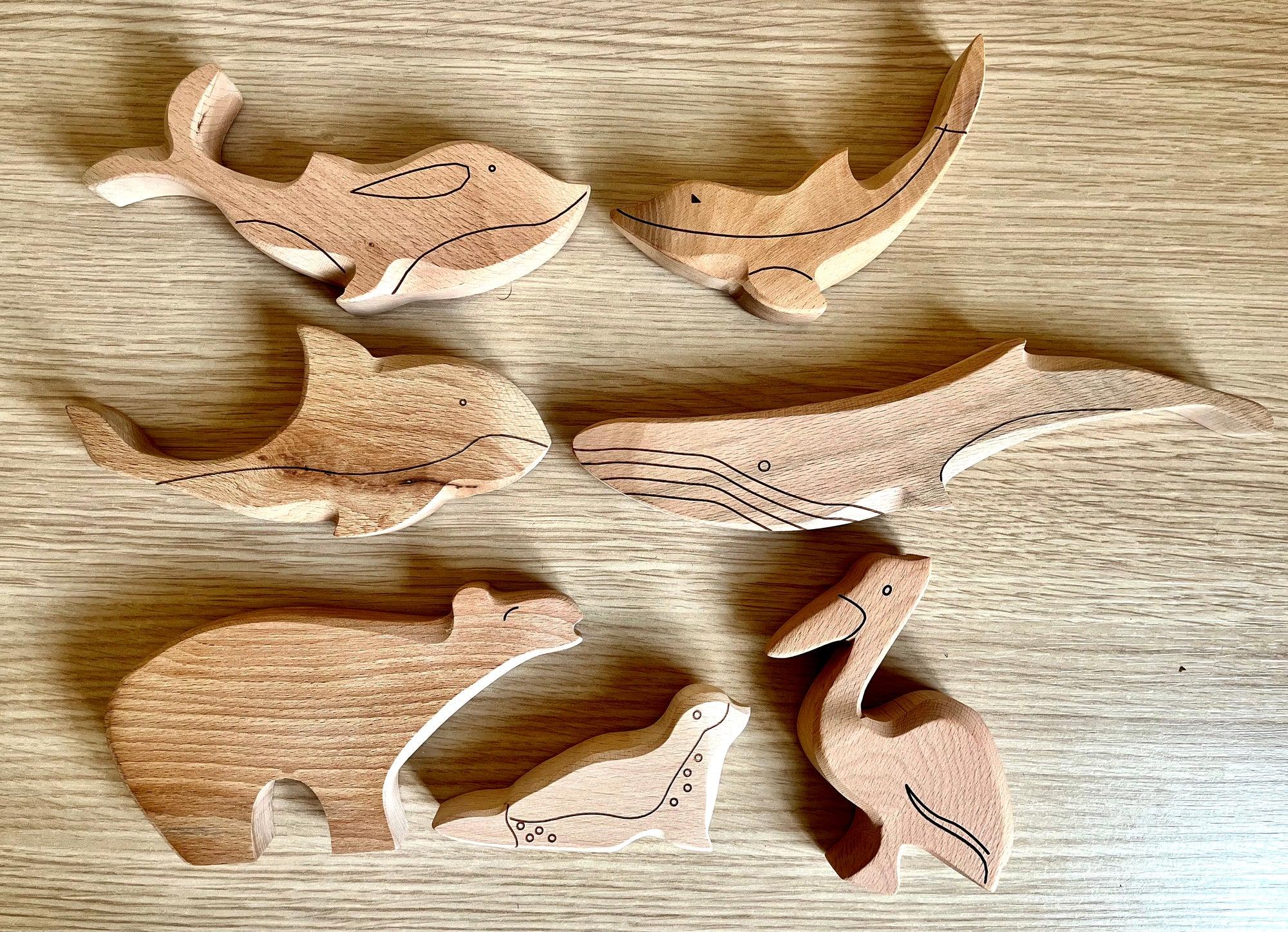 A colorful Wooden Ocean Animals Set featuring a dolphin, whale, sea turtle, starfish, and clownfish, designed for children's play and education.