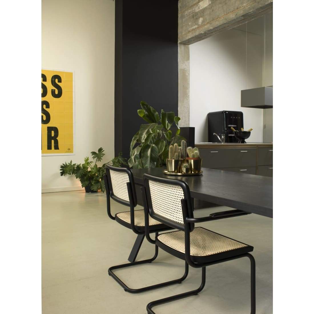 Workliving Bas Eetkamerstoel featuring a sleek black rattan design with armrests, perfect for dining rooms.