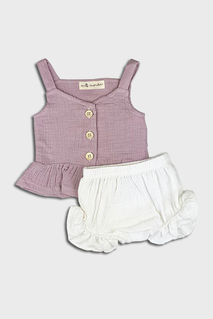 A stylish 2 pc linen set featuring a pink tank top with wooden buttons and ruffle hem, paired with white bloomer shorts with ruffles.