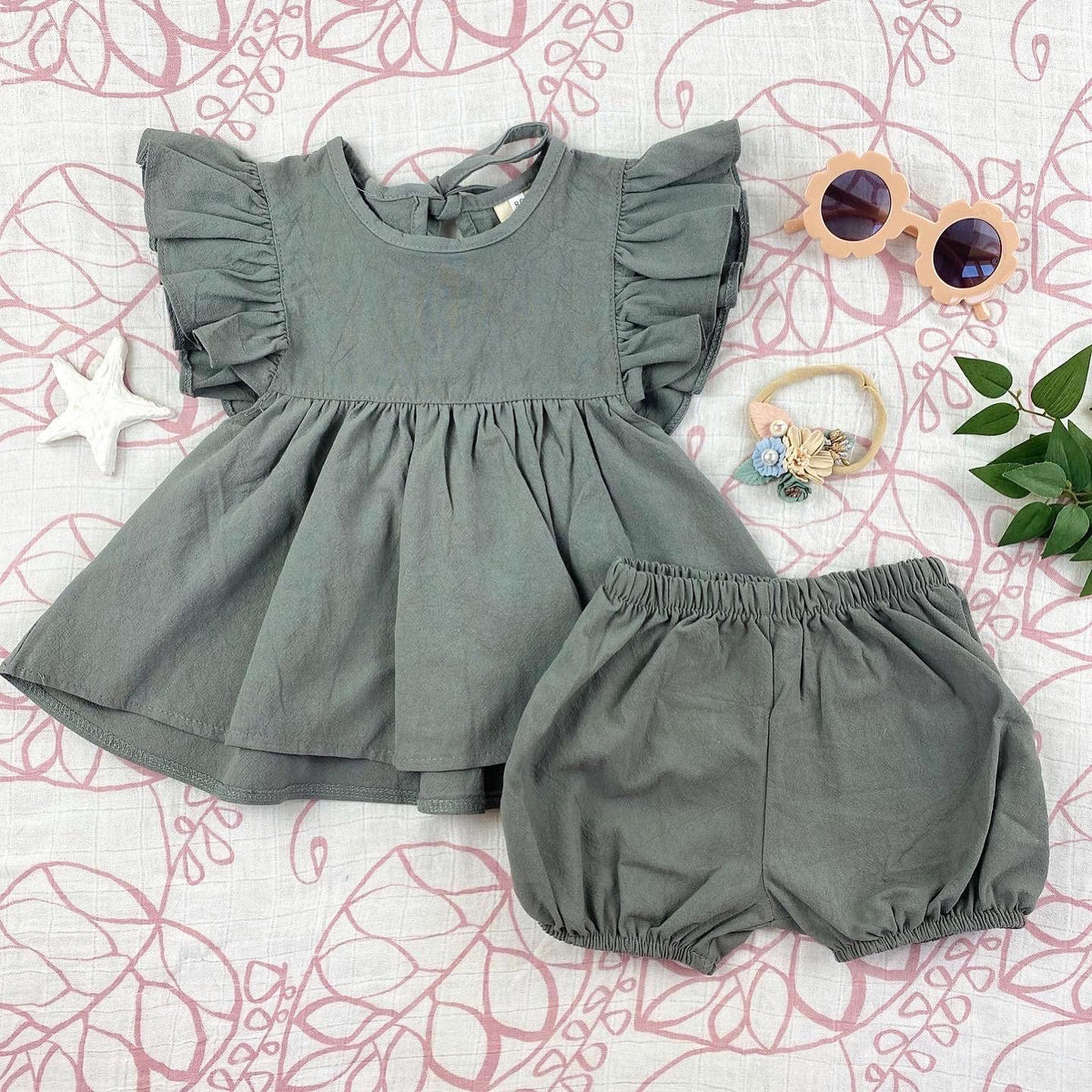 A stylish 2 pc set in vintage green featuring a flowing dress-like top with flutter sleeves and matching bloomer bottoms.