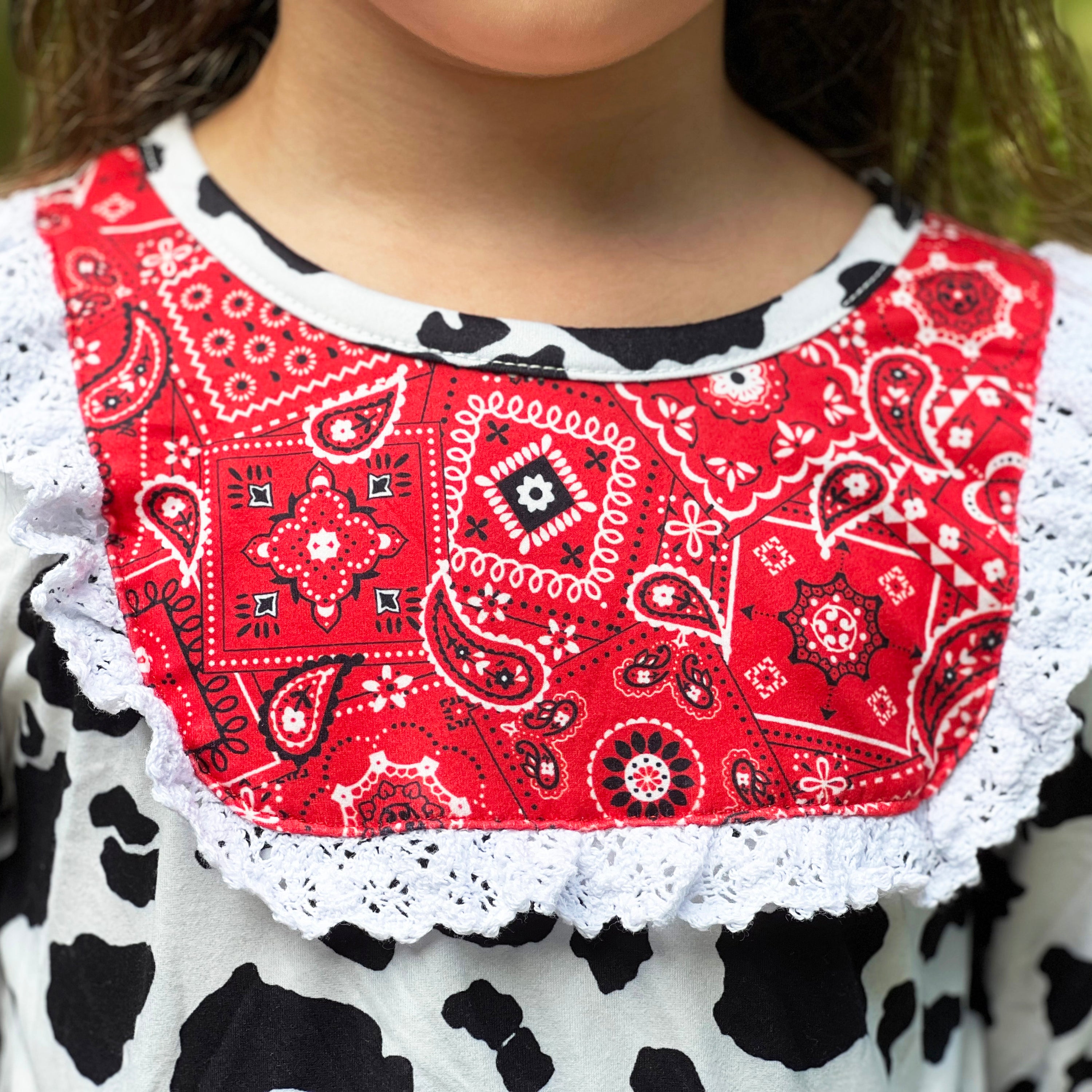 AL Limited Girls Boutique Cowgirl Dress featuring playful cow print and red bandana trimming with white eyelet ruffle accents.