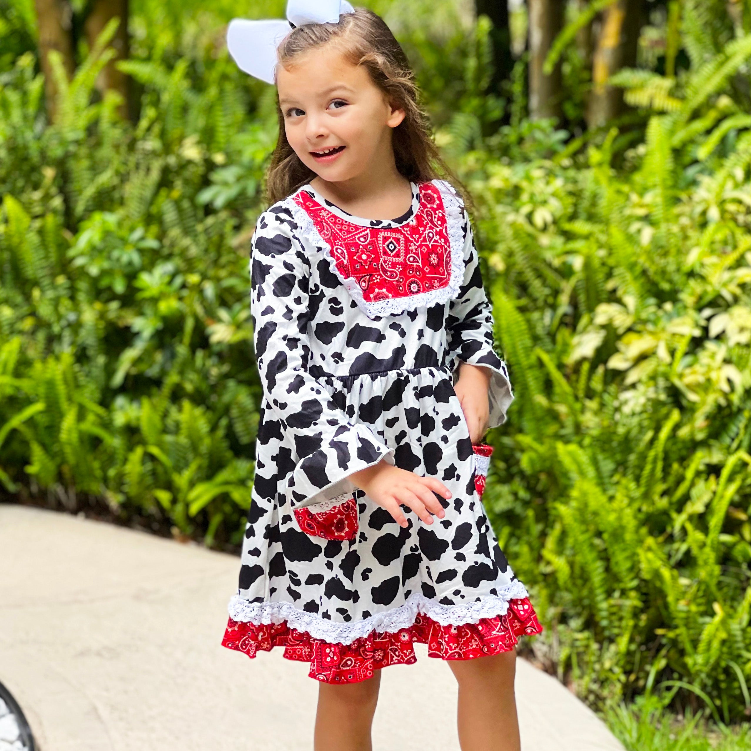 AL Limited Girls Boutique Cowgirl Dress featuring playful cow print and red bandana trimming with white eyelet ruffle accents.