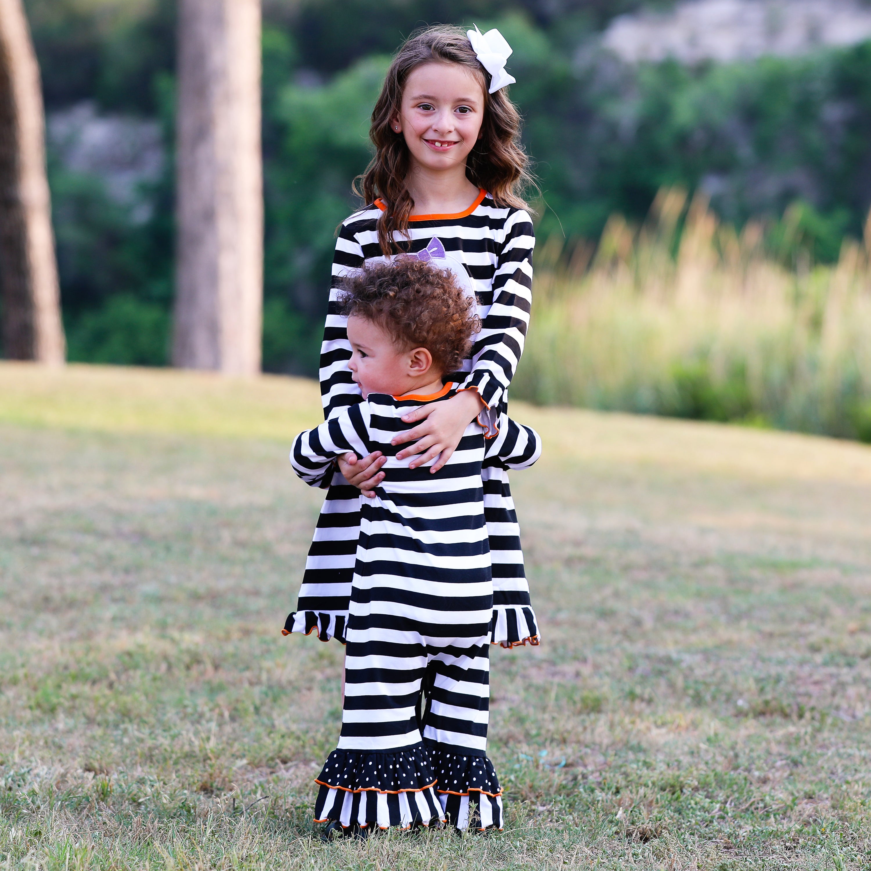 AnnLoren Baby Girls Halloween romper featuring friendly ghost applique and black and white stripes with polka dot ruffles.