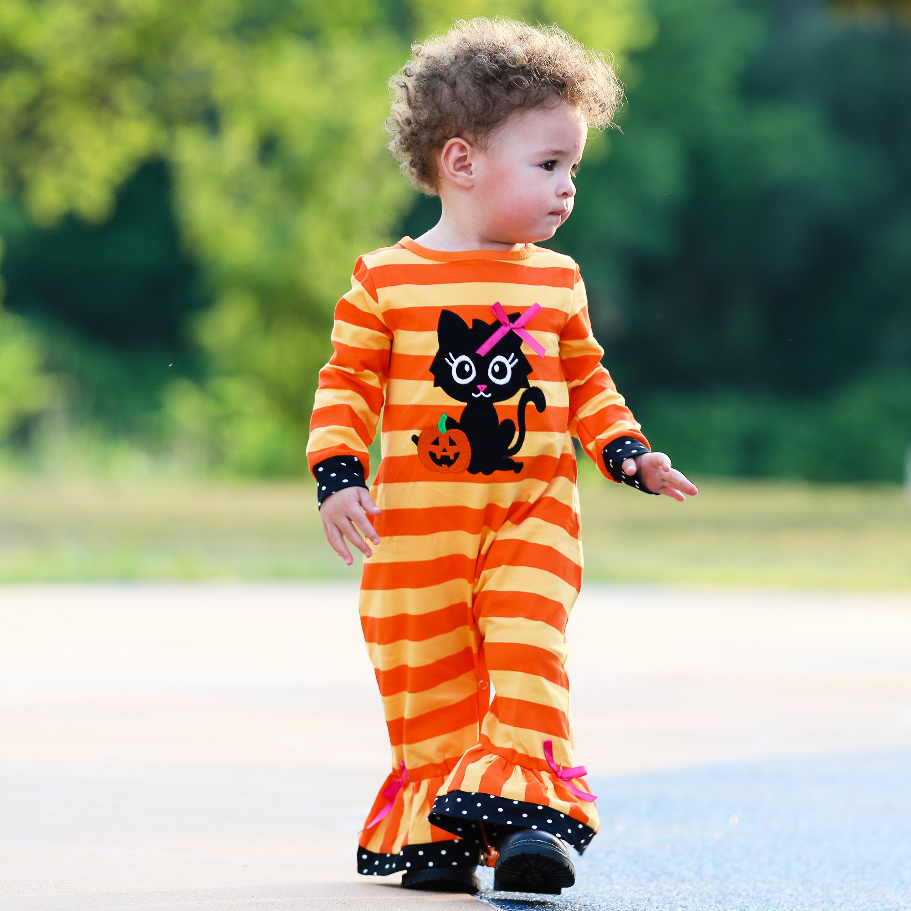 AnnLoren Baby Girls Halloween romper featuring a friendly black cat applique and orange striped design with polka dot trim.