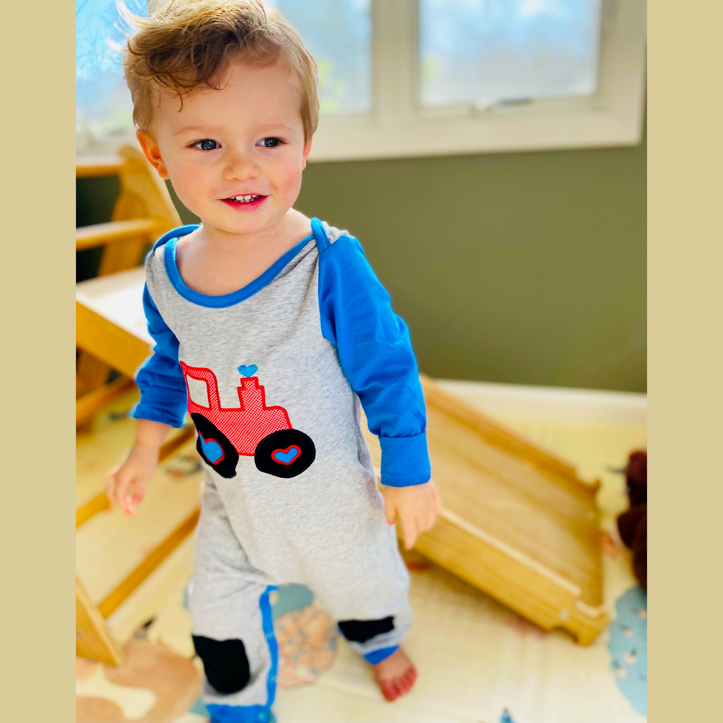 AnnLoren Baby Toddler Boys Long Sleeve Truck Romper in blue and grey with red truck appliqué and knee patches.