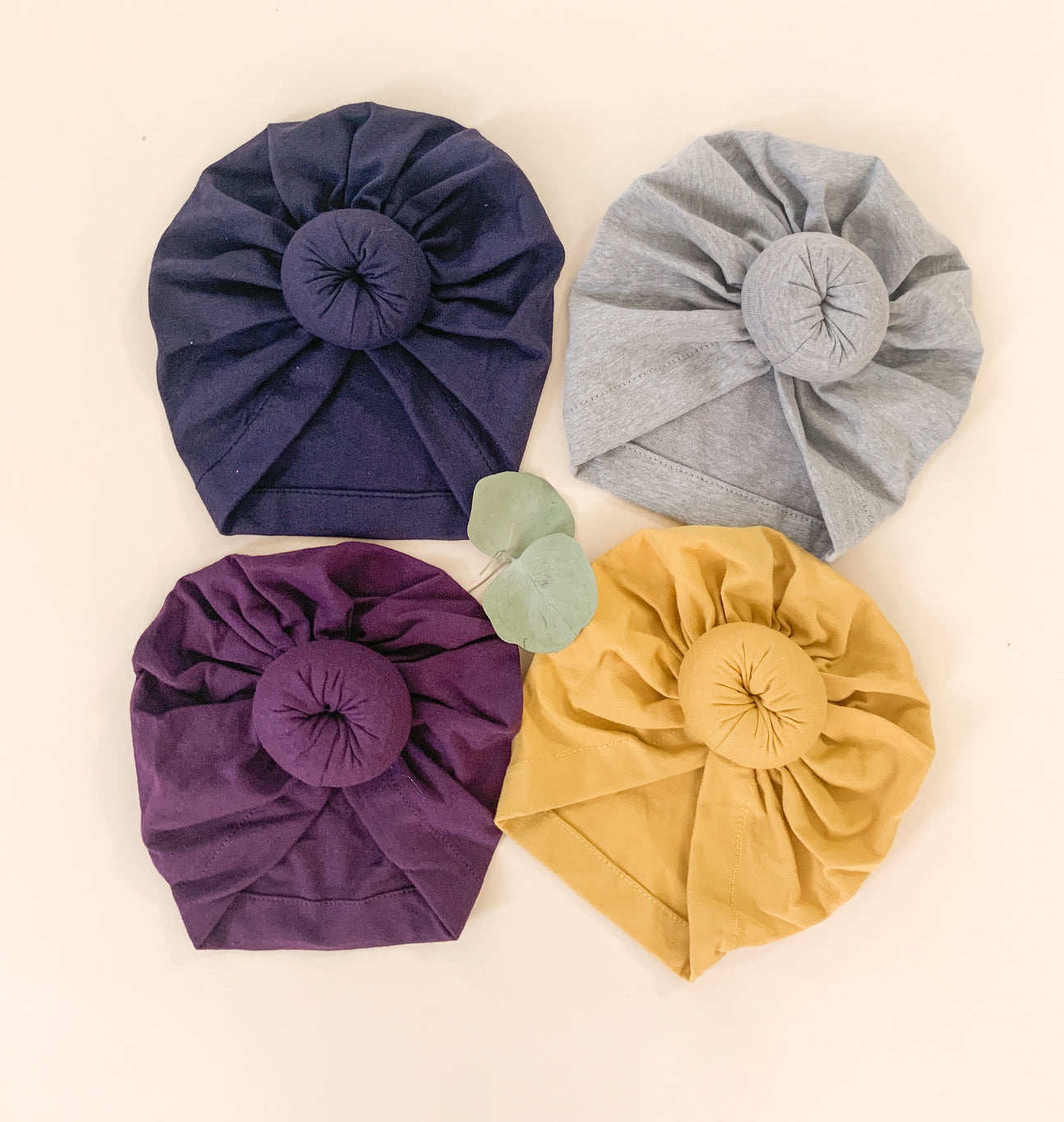 A soft and stylish baby knot turban in various colors, designed for infants aged 0-18 months, featuring a trendy knot design.