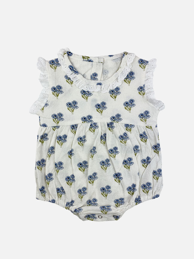 A blue floral Belle Onesie made of soft cotton, featuring eyelet lace details on the collar and sleeves, perfect for babies.