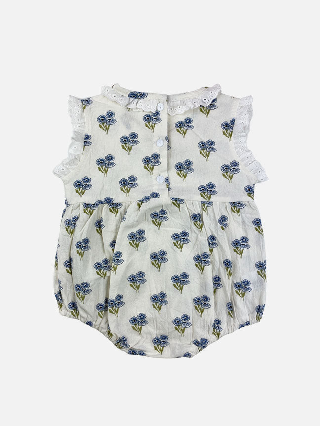 A blue floral Belle Onesie made of soft cotton, featuring eyelet lace details on the collar and sleeves, perfect for babies.