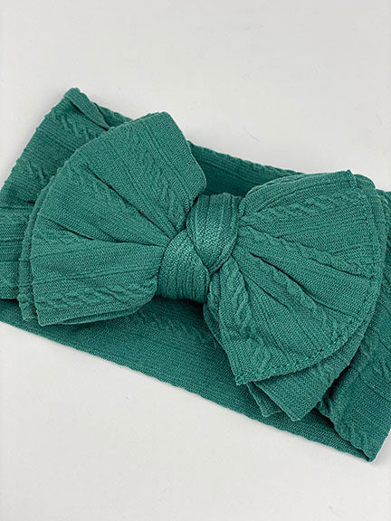 A big bow knotted headband in soft textured nylon, featuring a large 5-inch bow, perfect for newborns to toddlers.