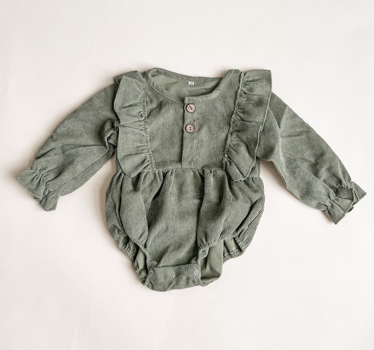 A stylish corduroy romper made from soft cotton, showcasing its unique texture and design.