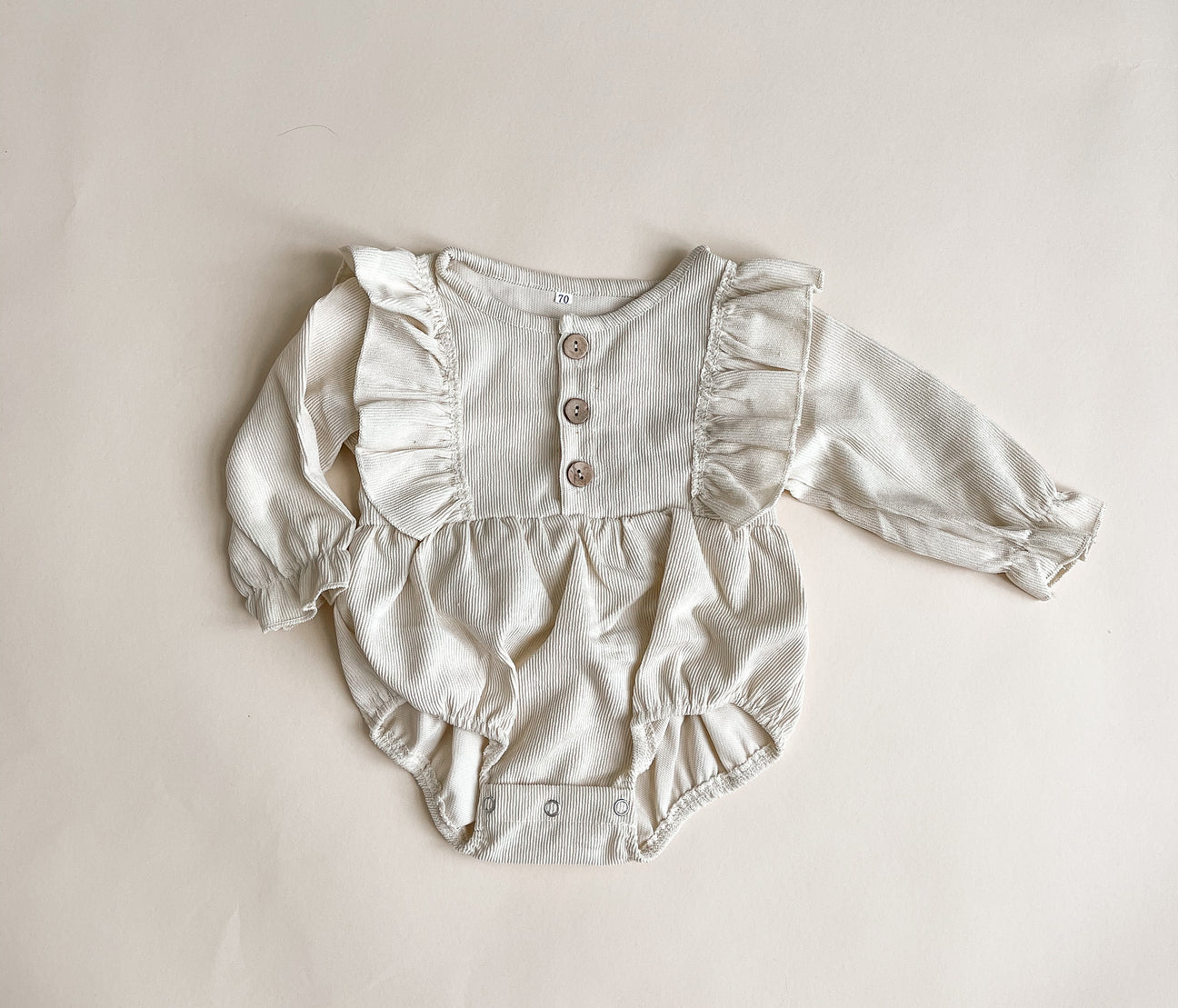 A stylish corduroy romper made from soft cotton, showcasing its unique texture and design.