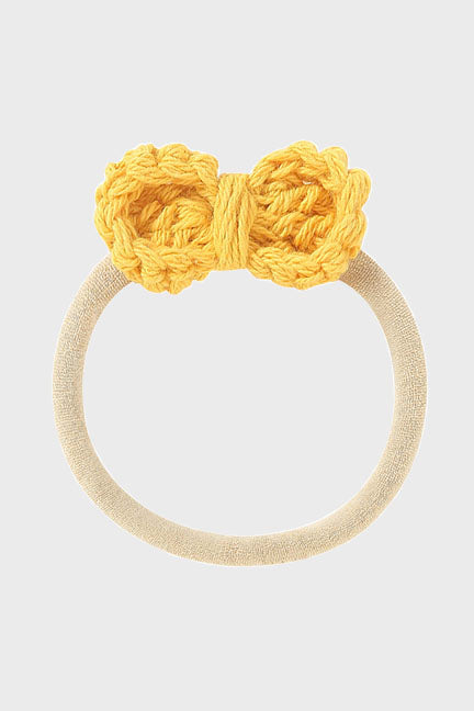 A soft crochet bow headband for babies, featuring a delicate bow design on a stretchy nylon band, perfect for ages newborn to 3 years.