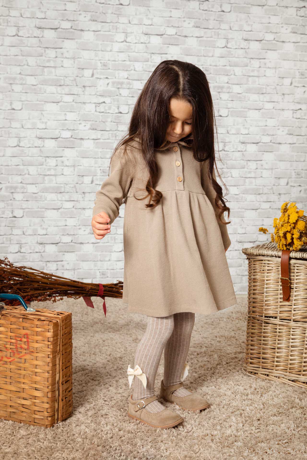 Dress Betty Coffee, a casual baby girl dress with olive wooden buttons, puff sleeves, and round collar in coffee color made from organic cotton.