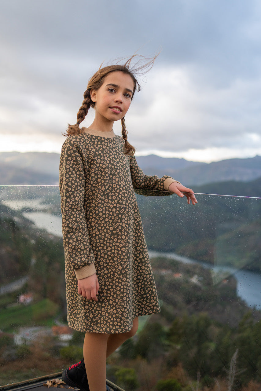 A stylish long sleeve dress featuring a khaki floral print, made from organic cotton fleece with ribbed cuffs and side pockets.