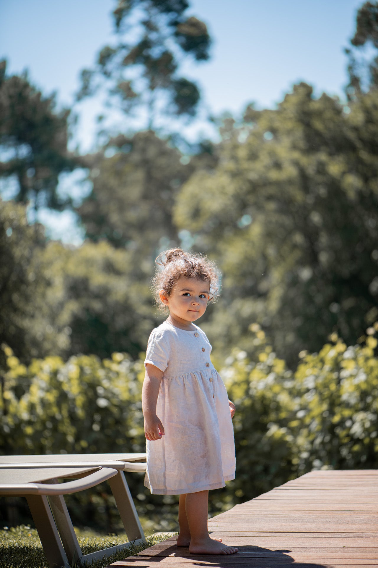 A stylish terracotta dress made of 100% linen, featuring short sleeves with rolled cuffs and olive wood button closure.