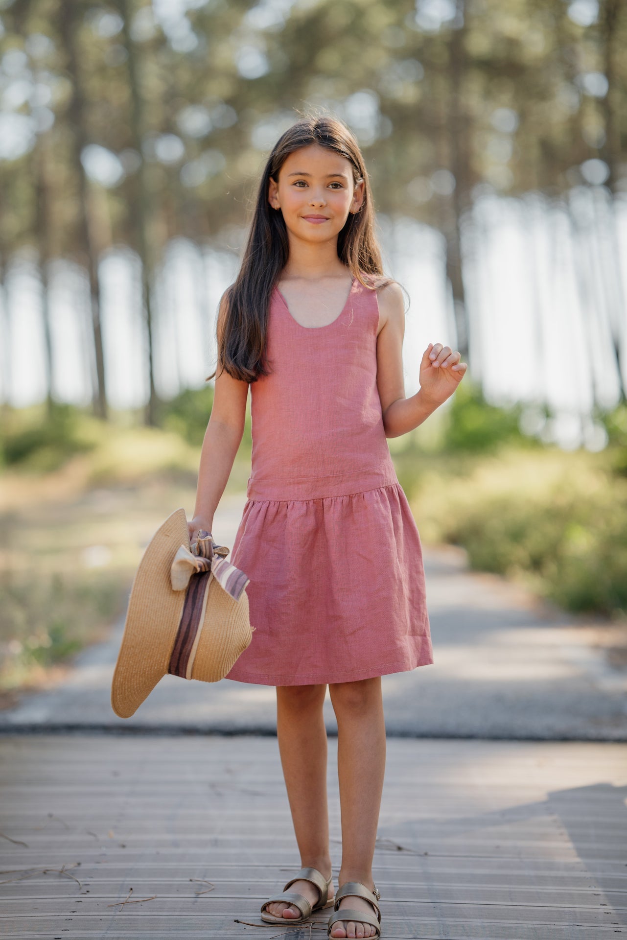 Dungaree Celeste dress in soft natural linen, featuring adjustable straps and a side zip, available in Rose, Blue Celeste, and Sienna Cream.