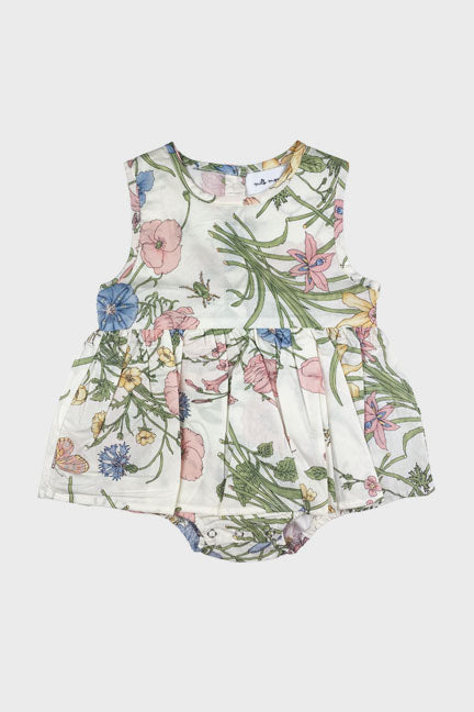 A charming ellerie onesie dress featuring a white base with a colorful spring fleur print, designed for toddlers with a circle skirt and bow detail.