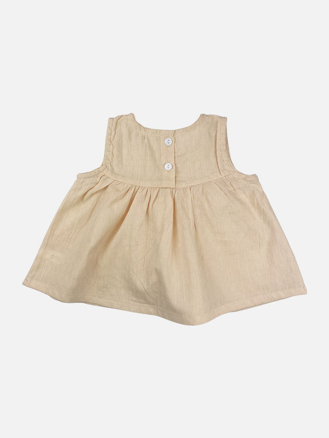 Eloise 2 pc set featuring a pale peach tank top with ruffles and matching bloomer shorts, made of textured cotton fabric.