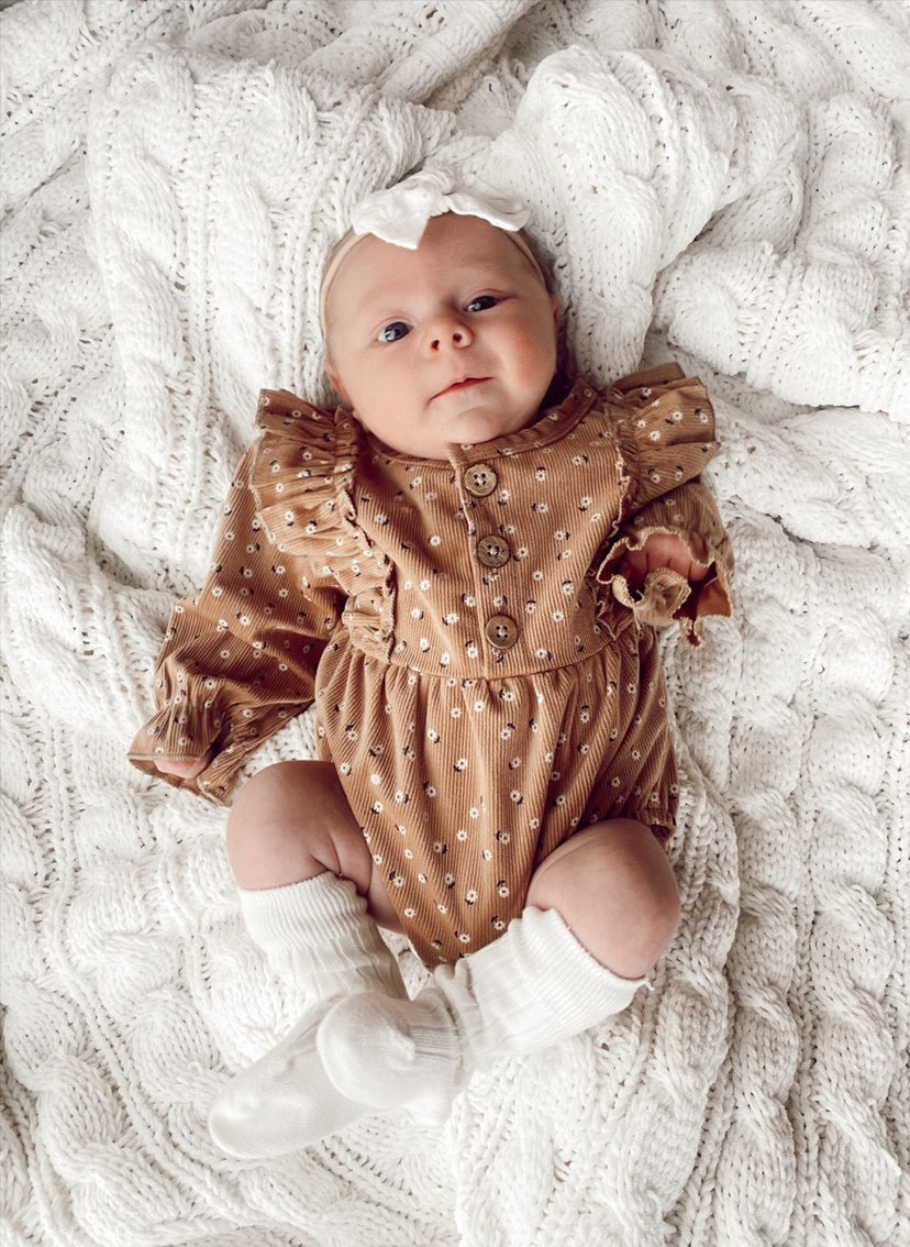 A stylish Floral Corduroy Romper made from soft cotton, featuring a vibrant floral pattern, perfect for casual outings.