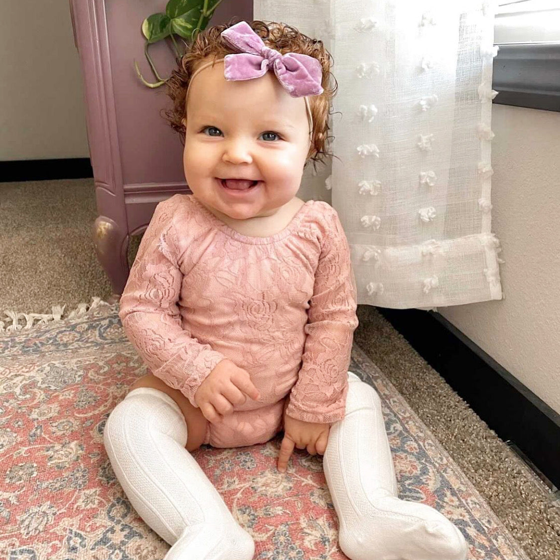 A beautiful floral lace onesie in rose color, featuring see-through lace sleeves and a solid rose leotard body, perfect for stylish comfort.